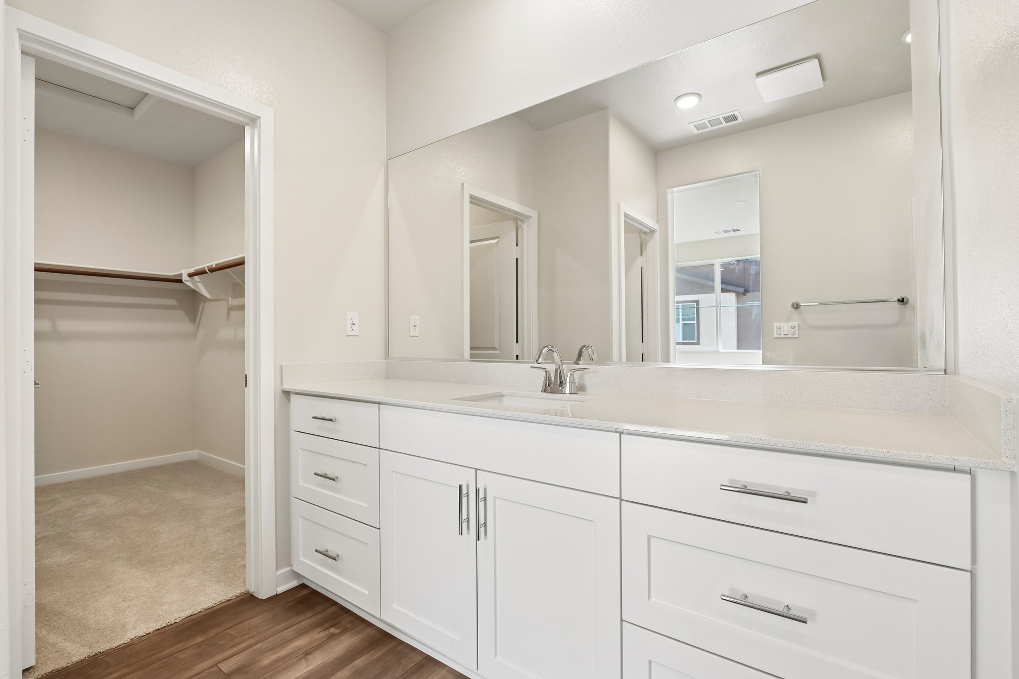 A bathroom with white cabinets.