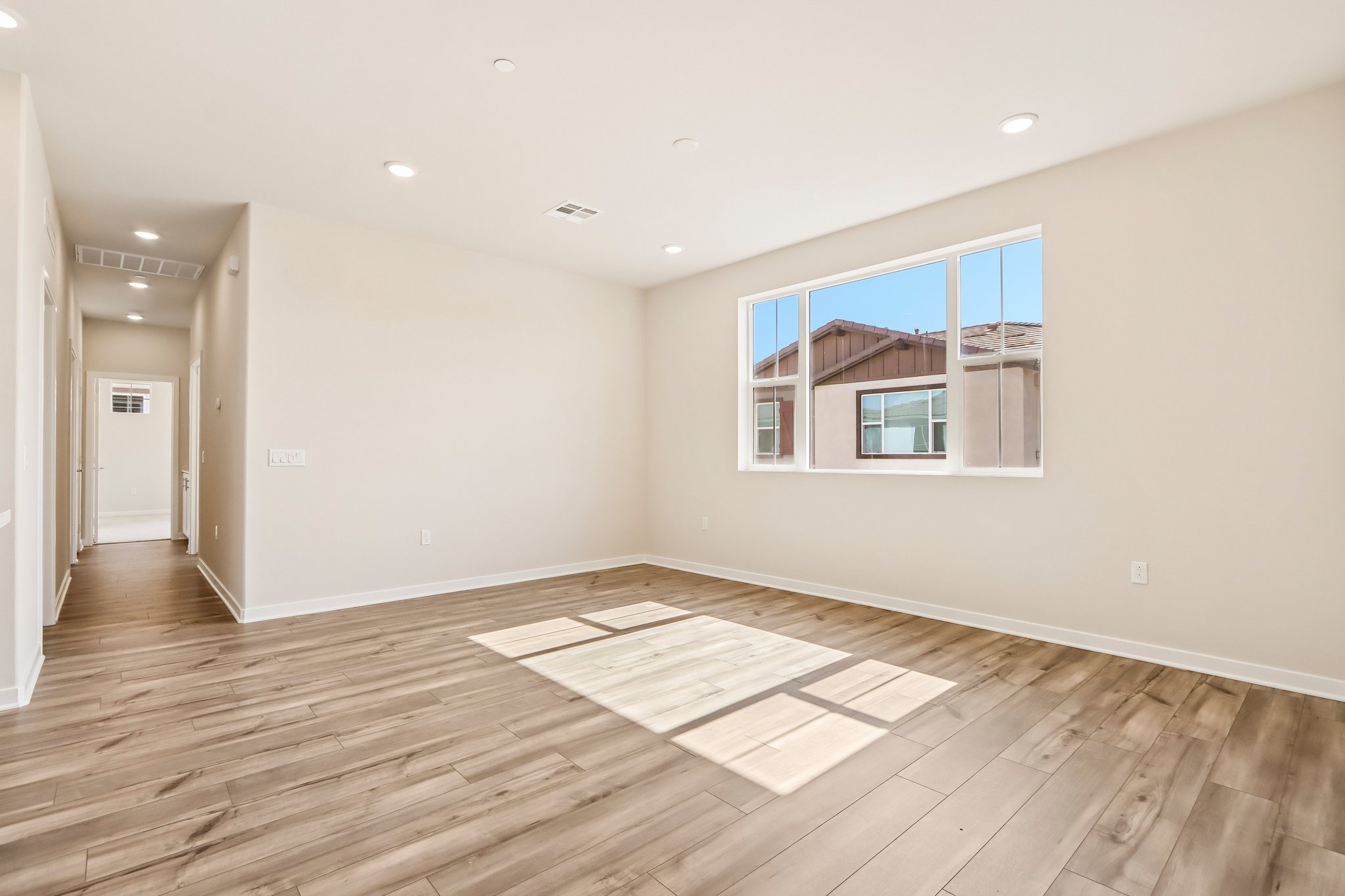 A room with a wood floor and a wood floor with a window.