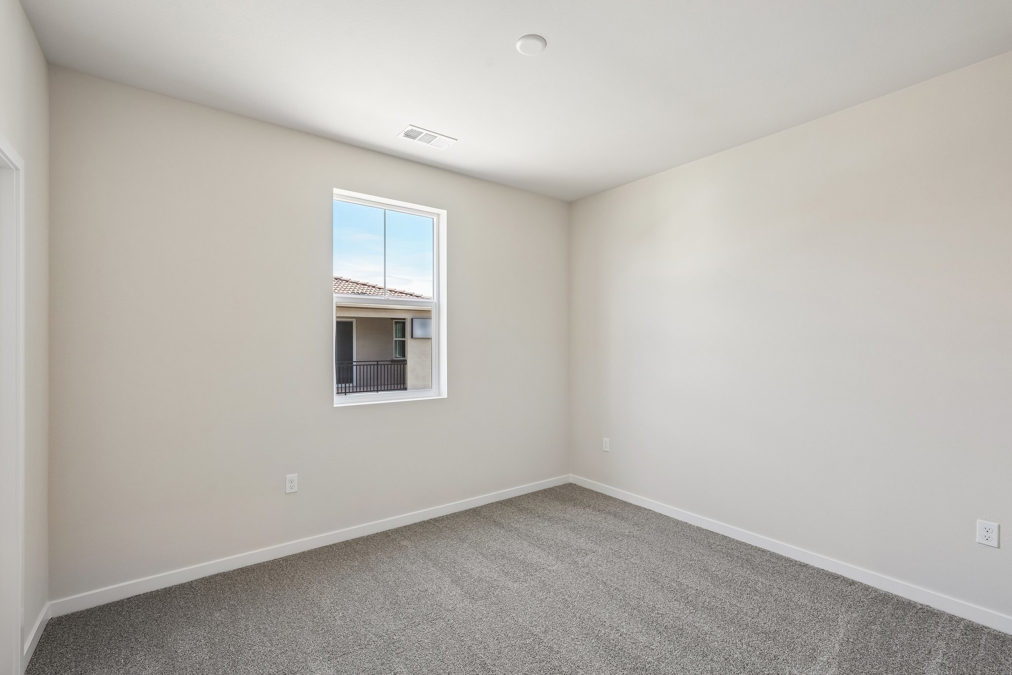 A room with a window and a carpet.