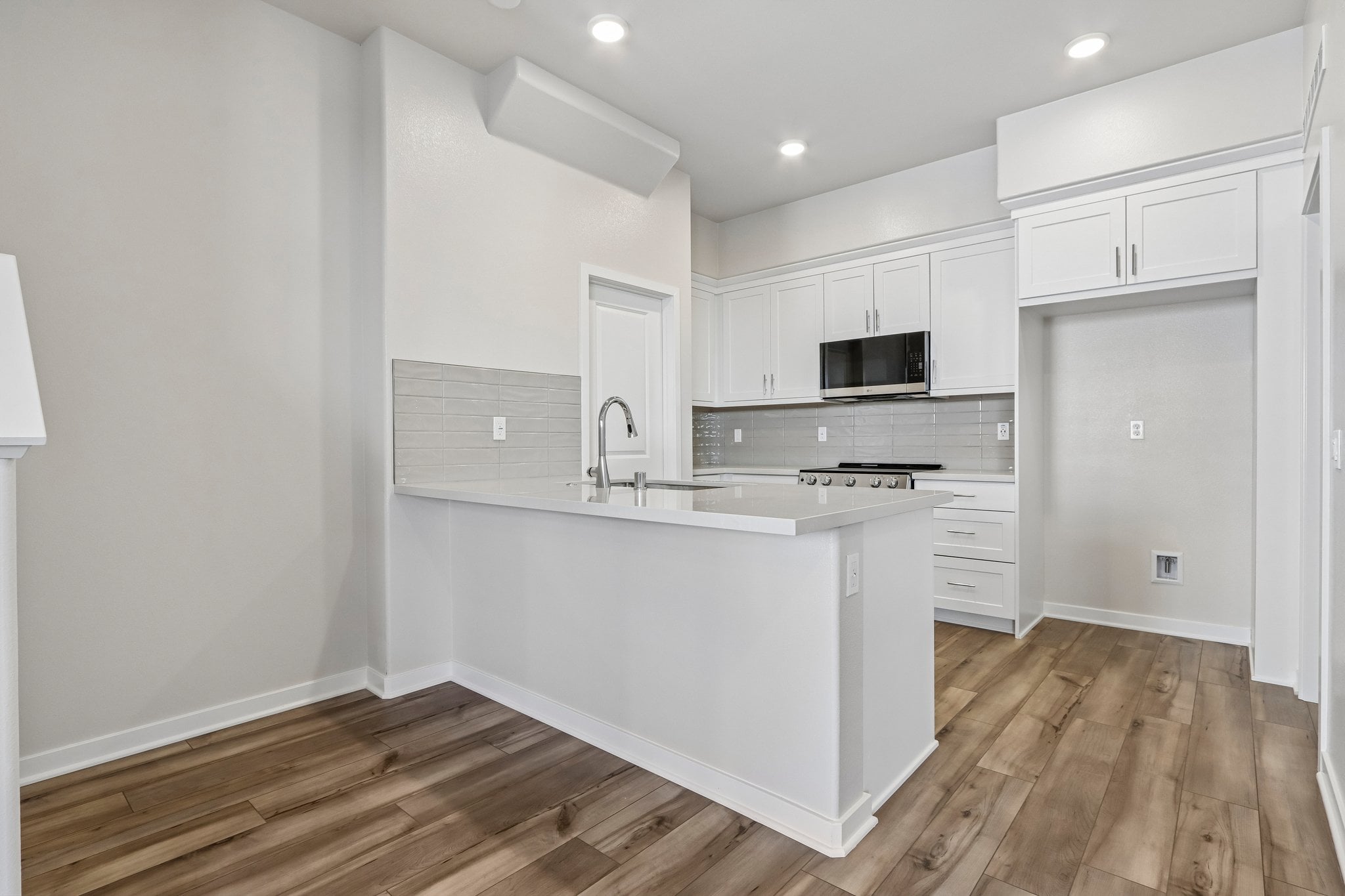 A kitchen with white cabinets.
