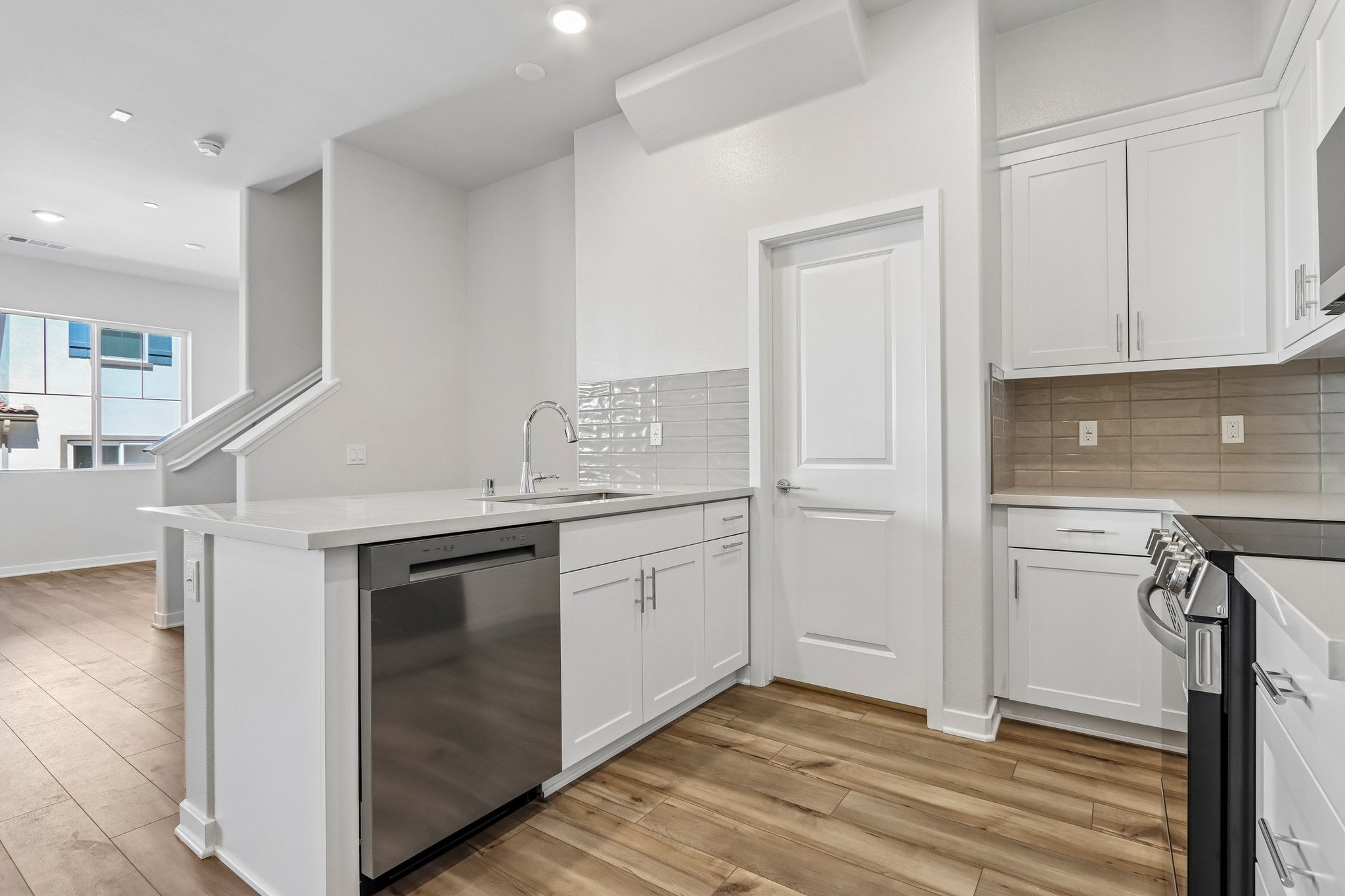 A kitchen with white cabinets.