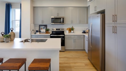 A kitchen with white cabinets.