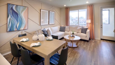 A living room with a large table and chairs.