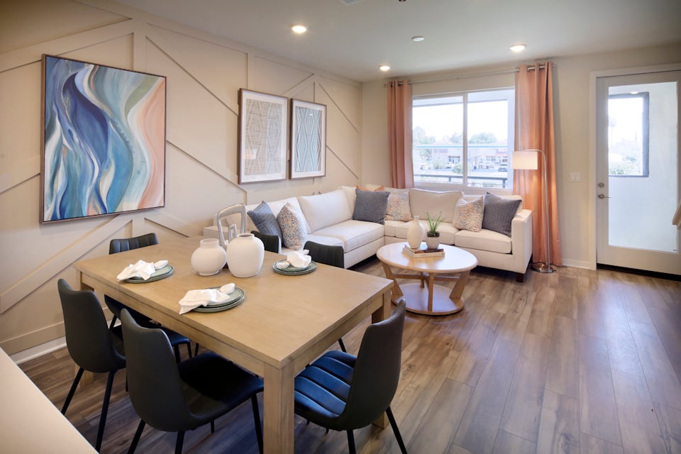 A living room with a large table and chairs.