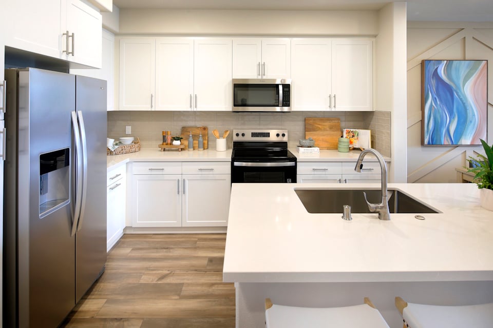 A kitchen with white cabinets.