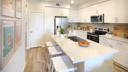 A kitchen with white cabinets.