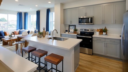 A kitchen with a bar stools.