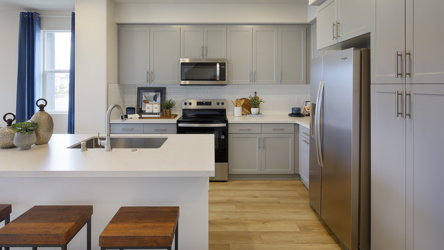 A kitchen with white cabinets.