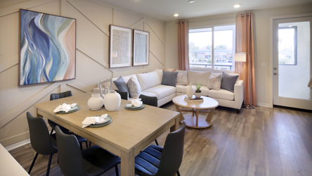 A living room with a large table and chairs.