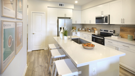 A kitchen with white cabinets.