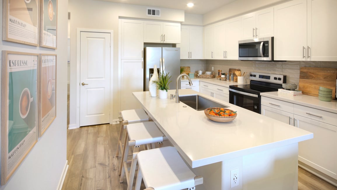 A kitchen with white cabinets.