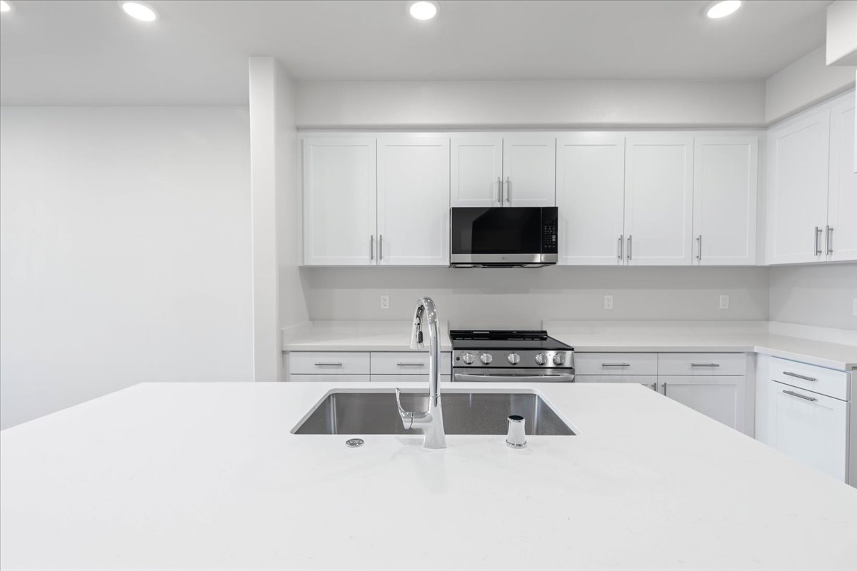 A kitchen with white cabinets.