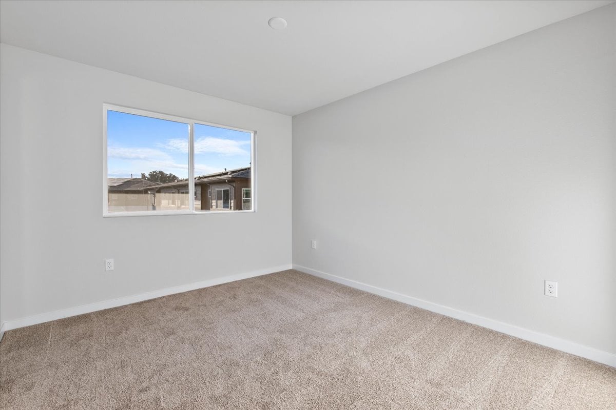 A room with a window and a carpet.