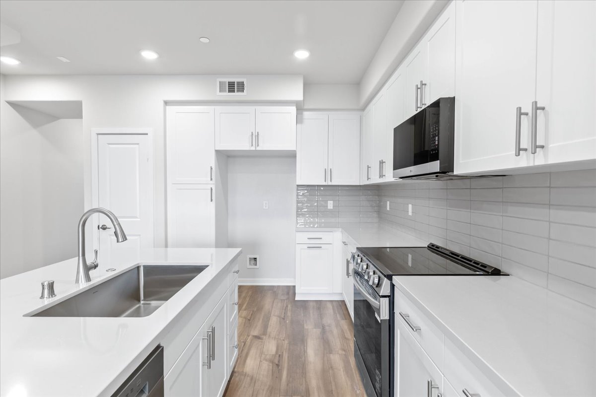A kitchen with white cabinets.