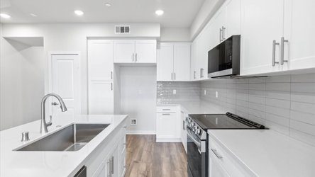 A kitchen with white cabinets.
