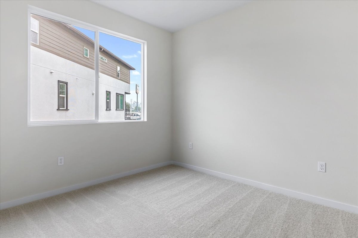 A room with a window and a white wall.