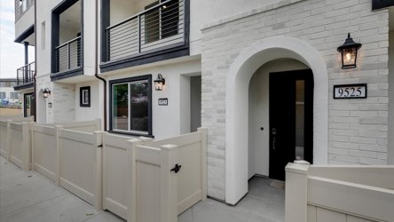 A white building with a white fence.