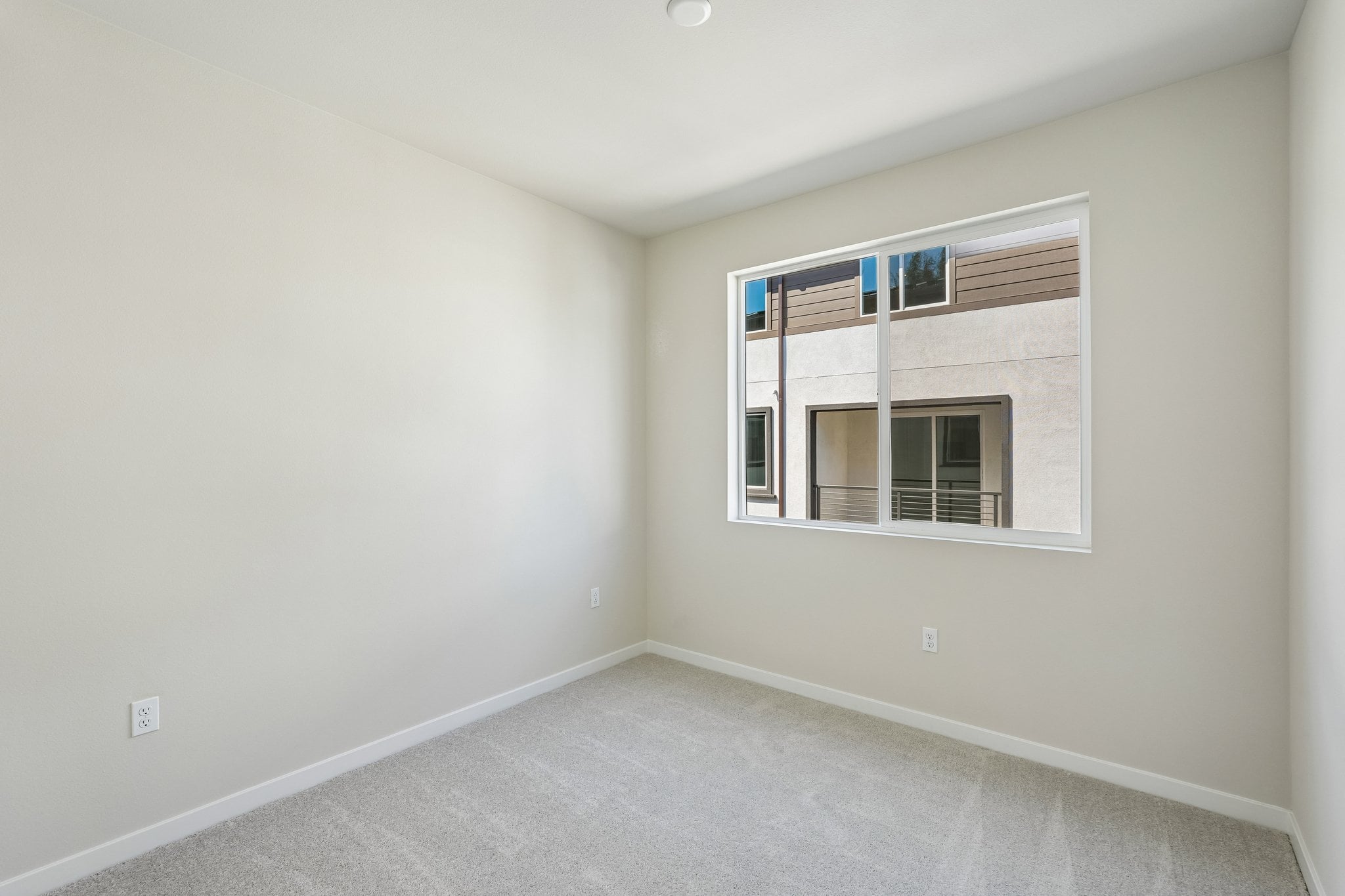 A room with a window and a white wall.