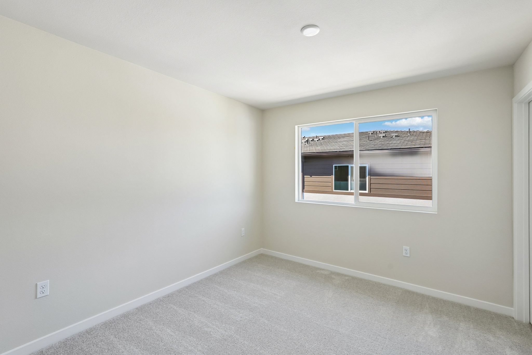 A room with a window and a carpet.
