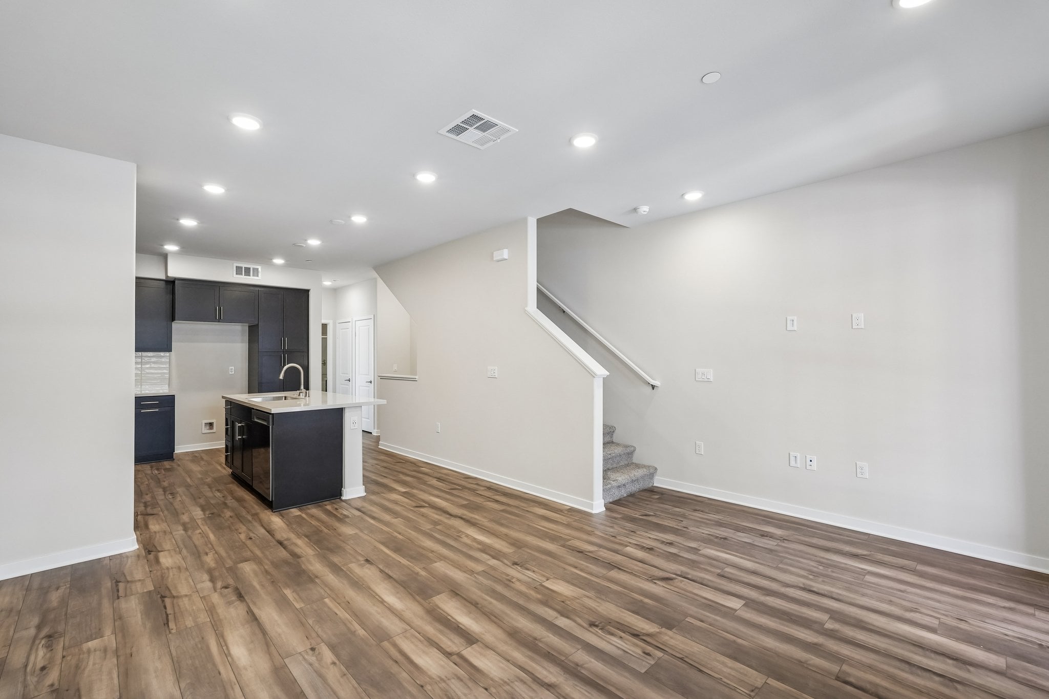 A room with white walls and wood floors.