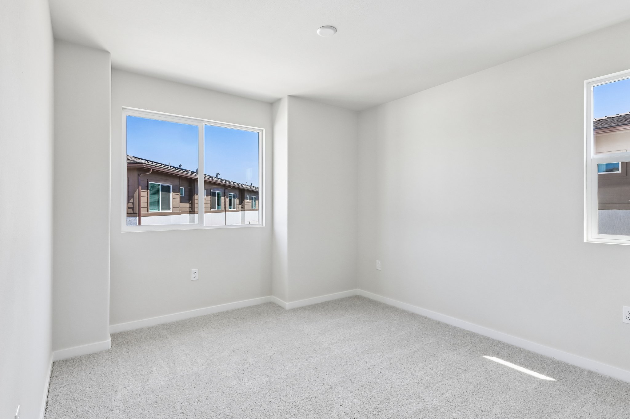 A room with a window and a white wall.