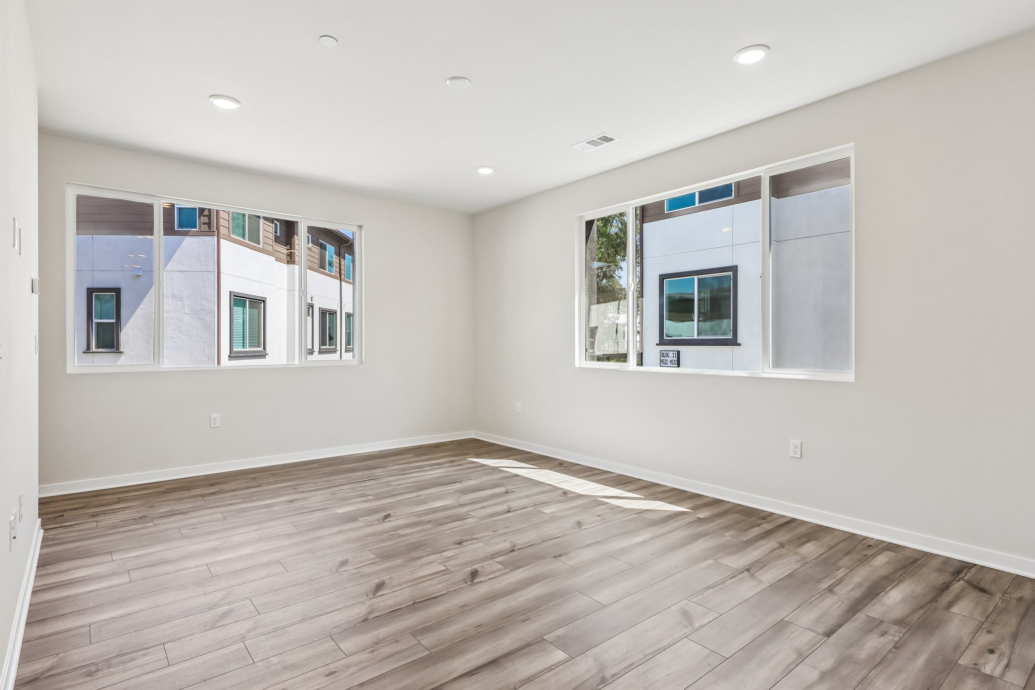 A room with a wood floor and a wood floor with a window.