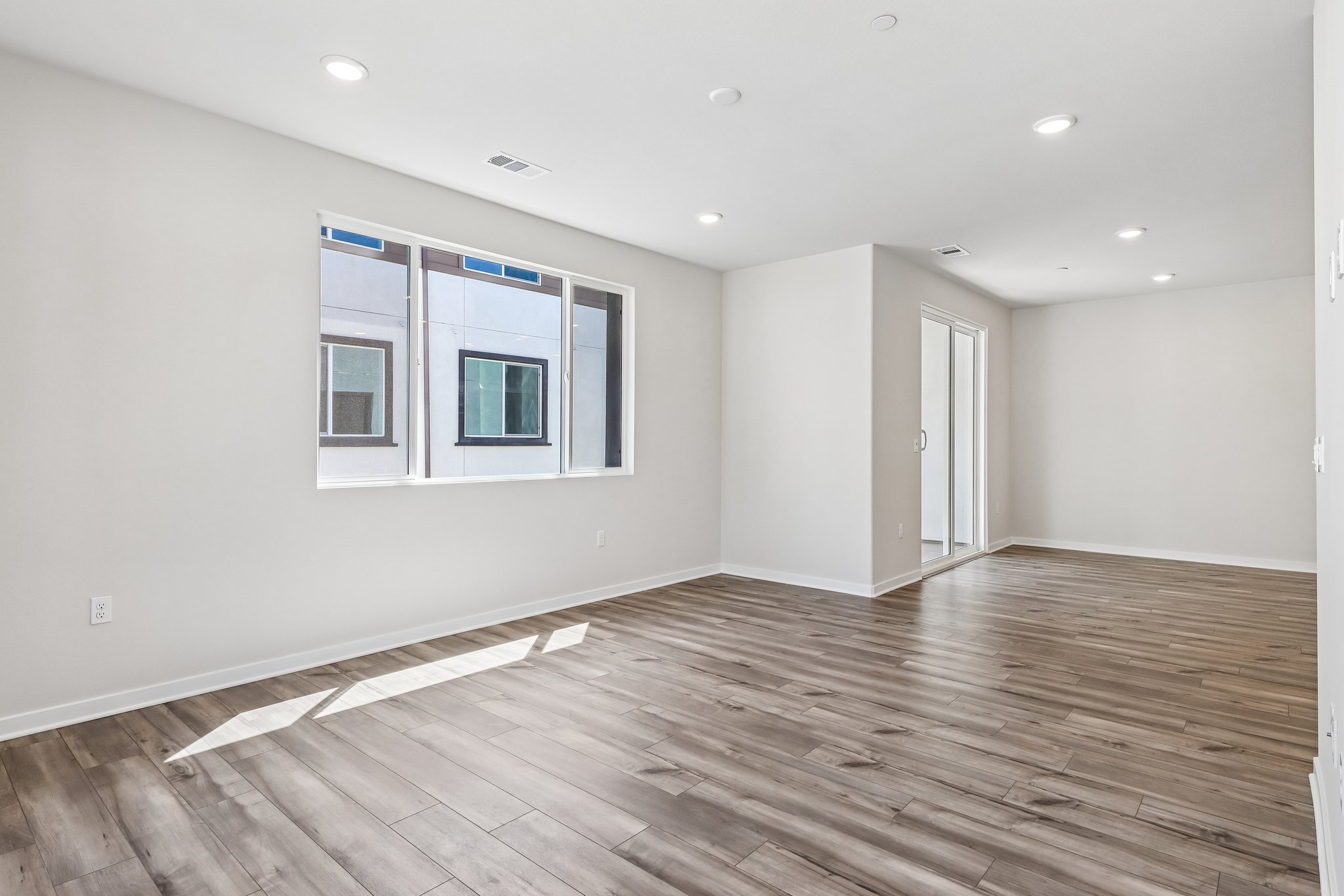 A room with a wood floor and a window.