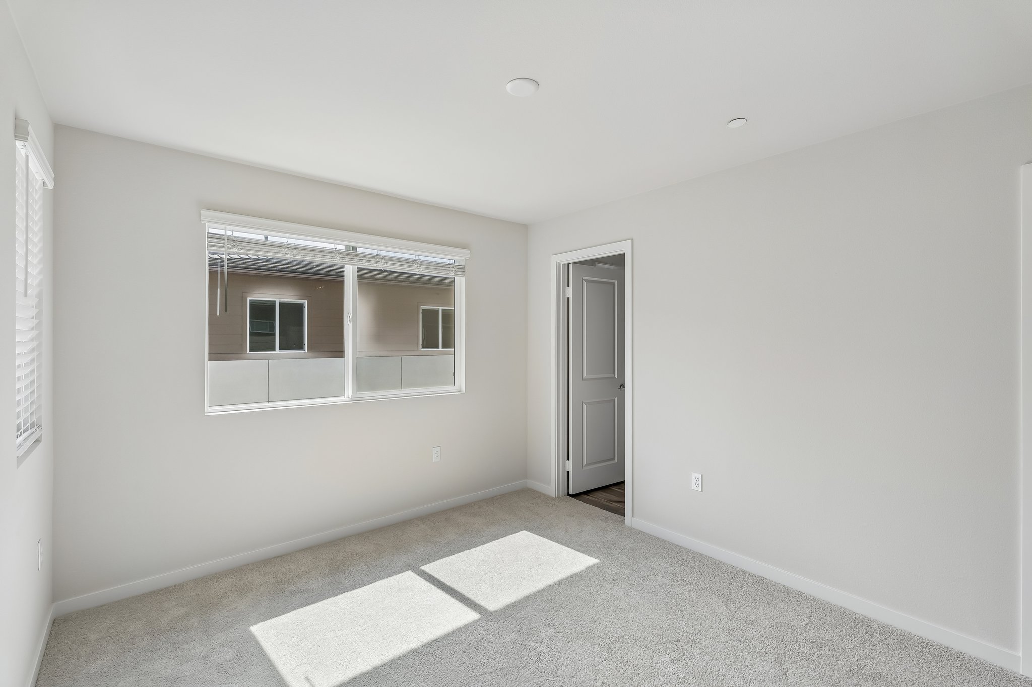 A room with a window and a rug.