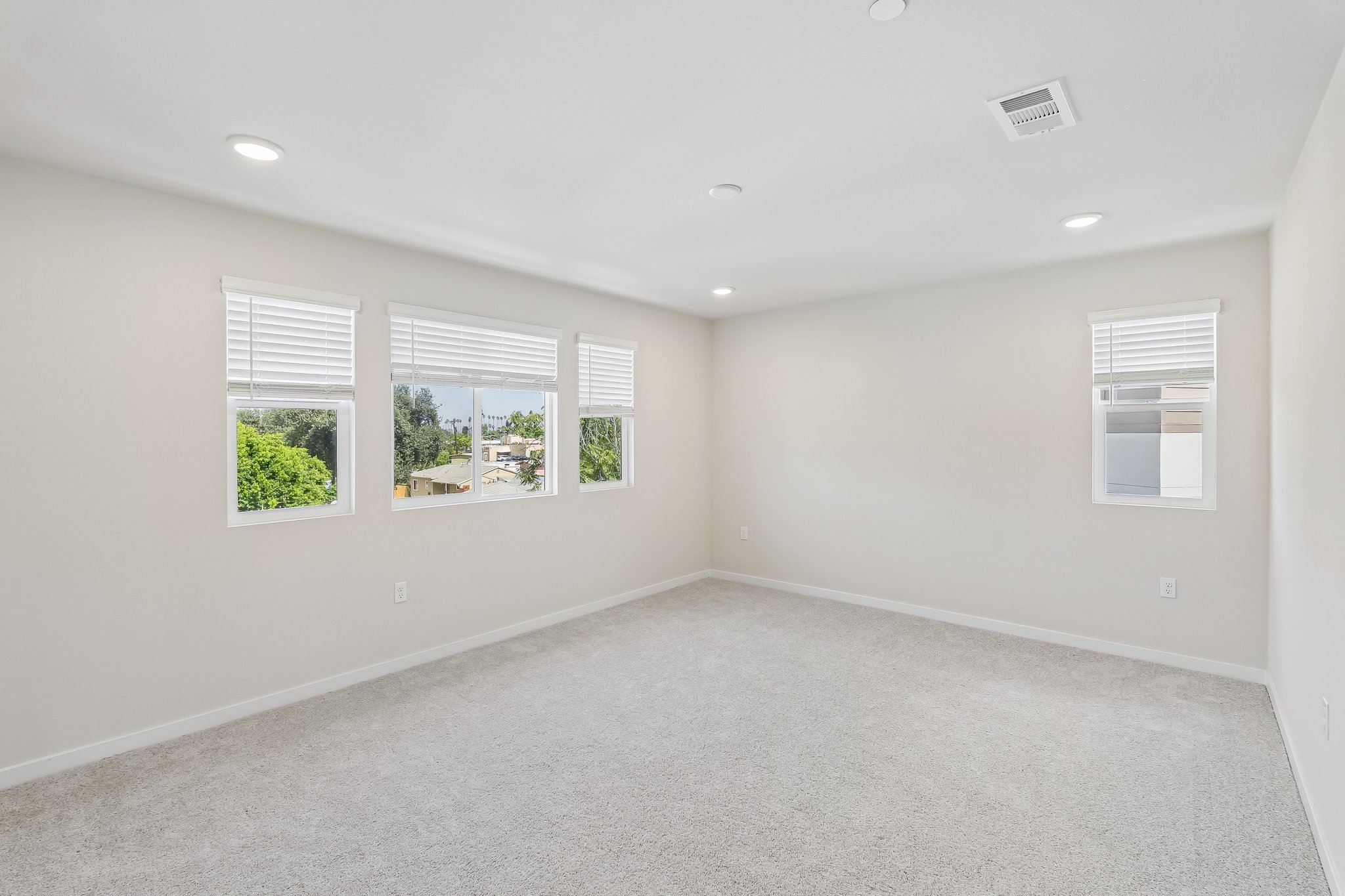 A room with windows and a white wall.