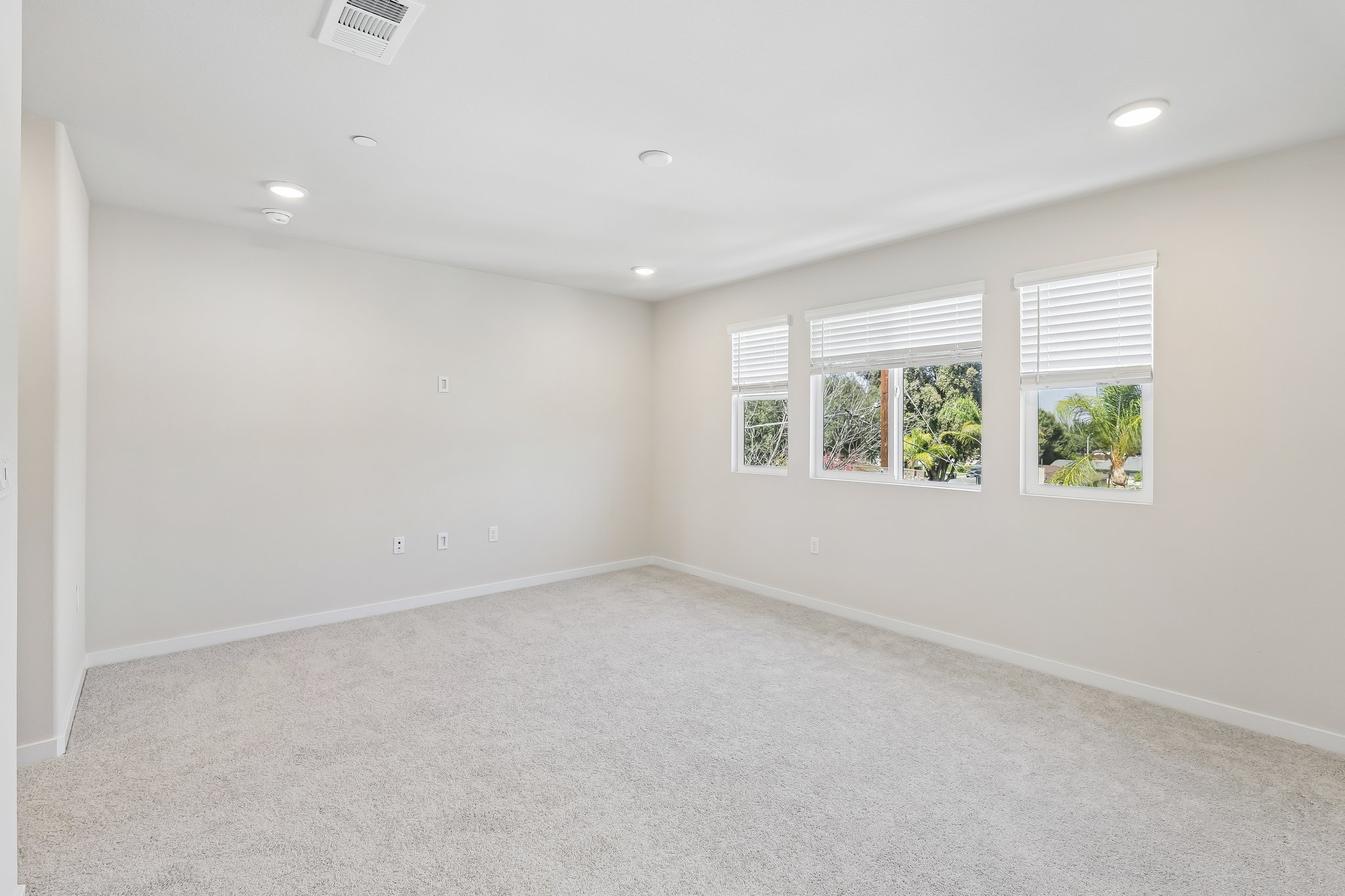 A room with a white wall and windows.