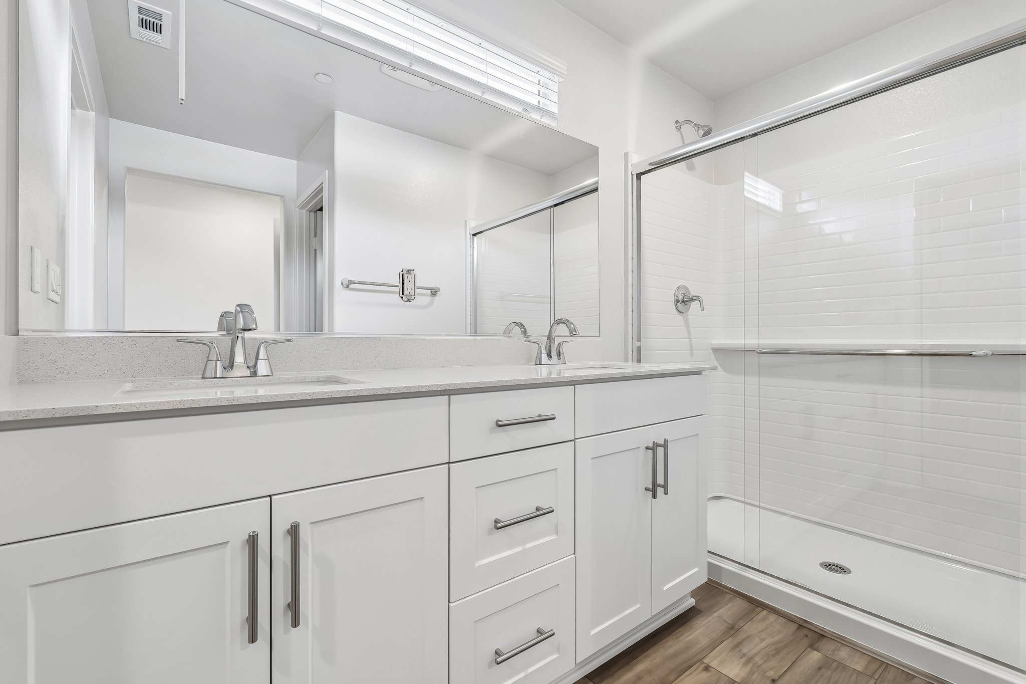 A bathroom with white cabinets.