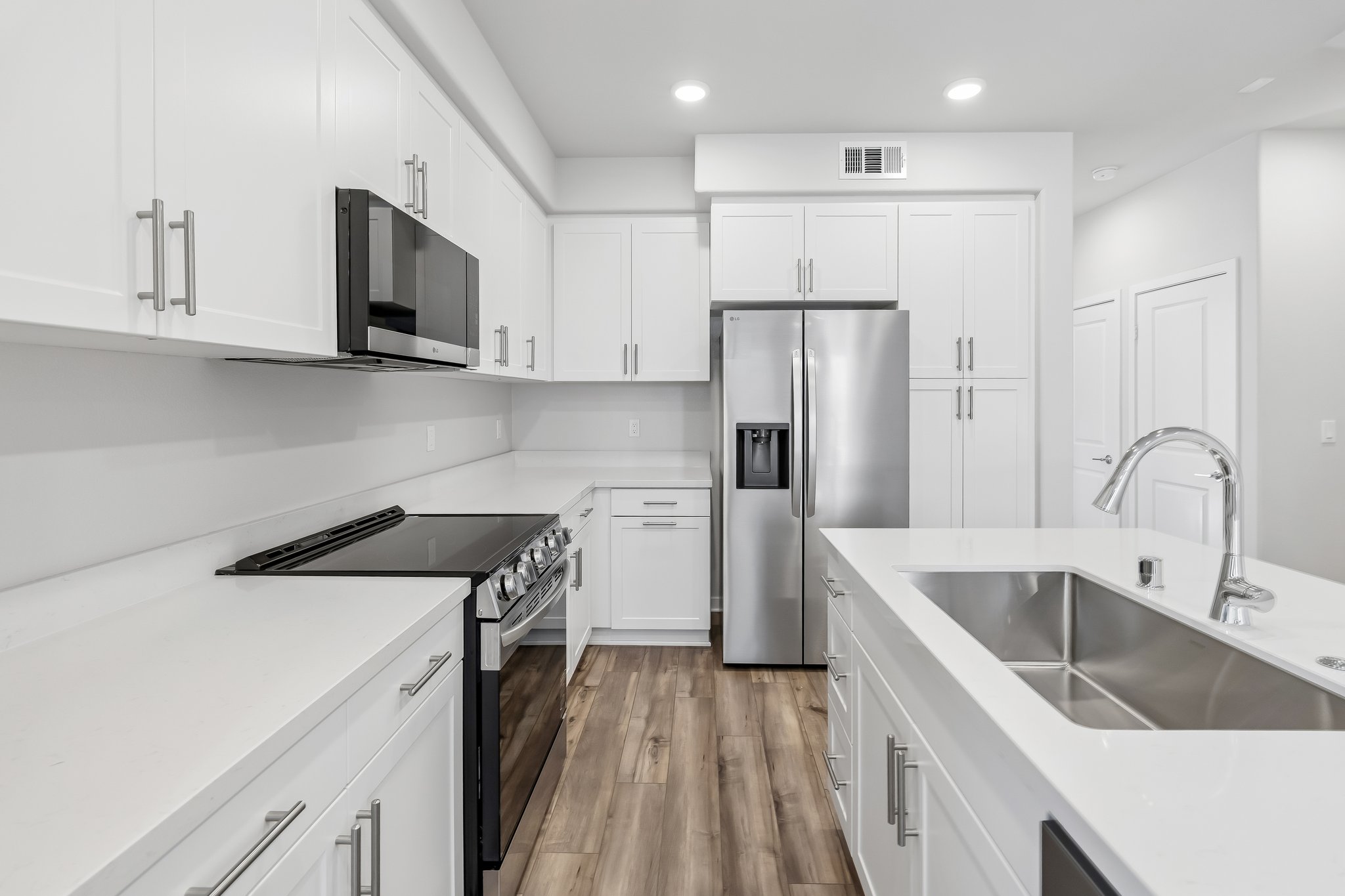 A kitchen with white cabinets.