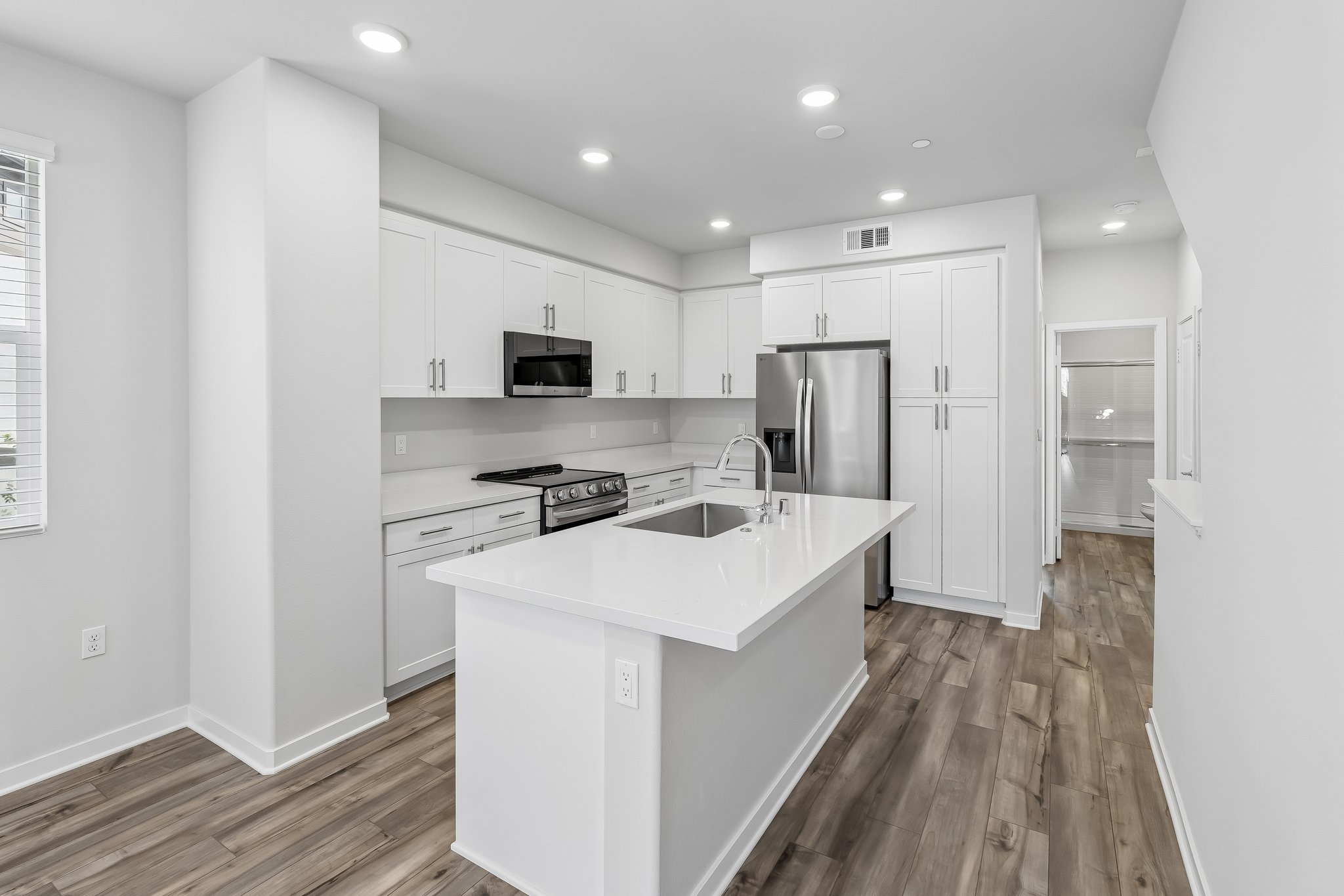 A kitchen with white cabinets.
