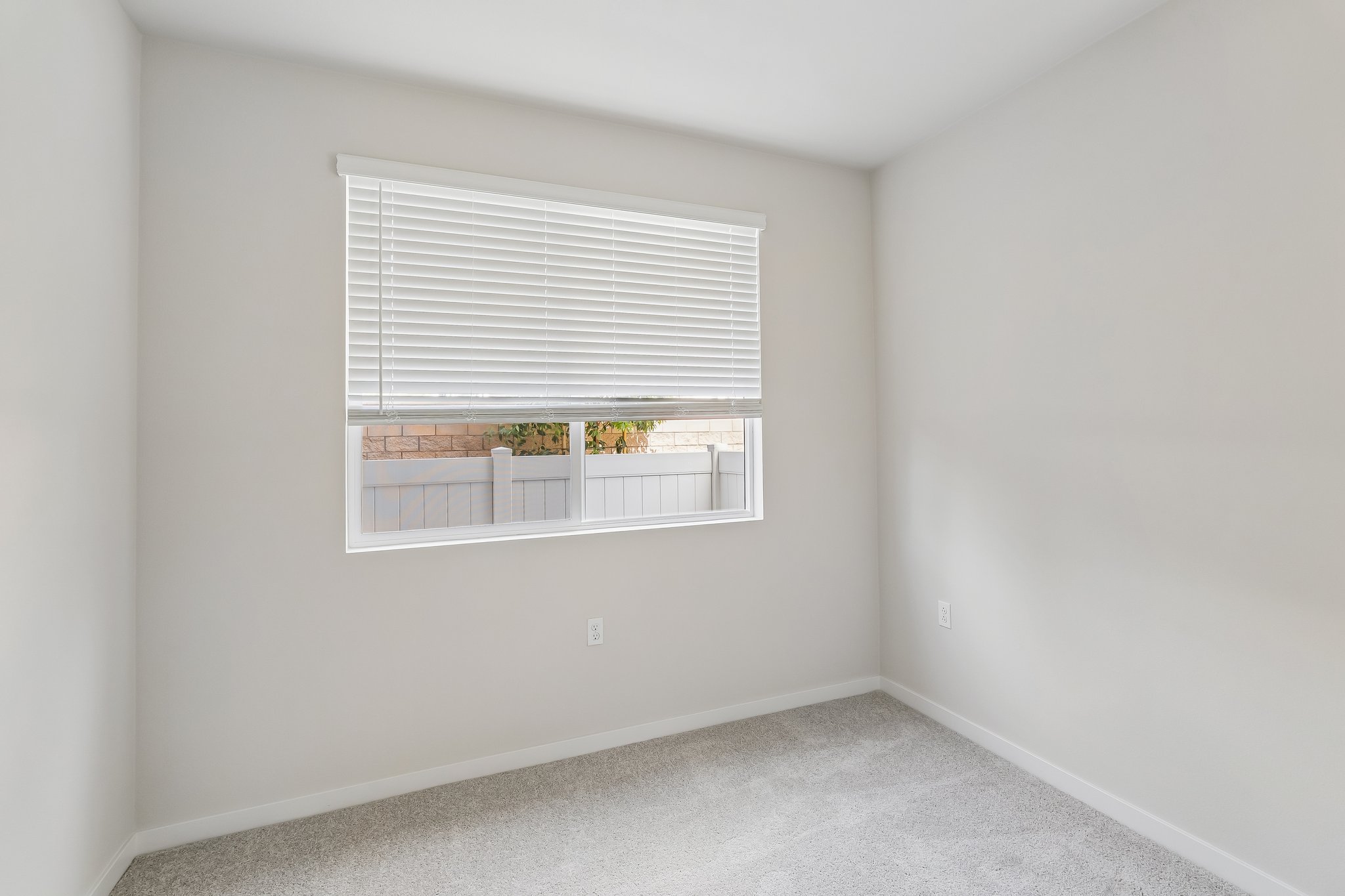 A room with a window and a rug.