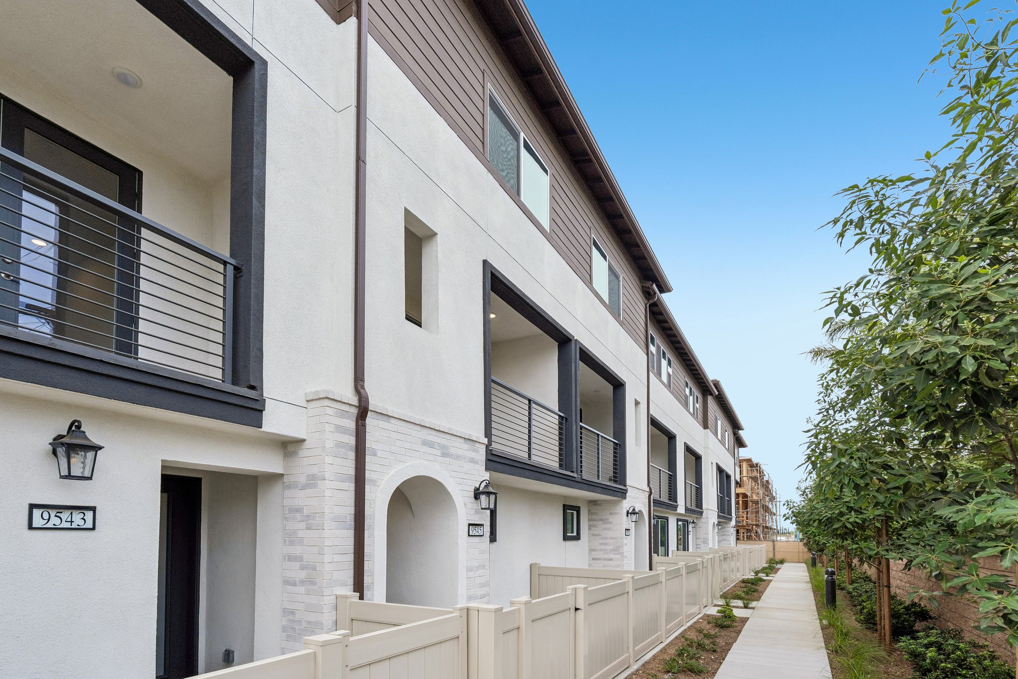 A white building with a white fence.