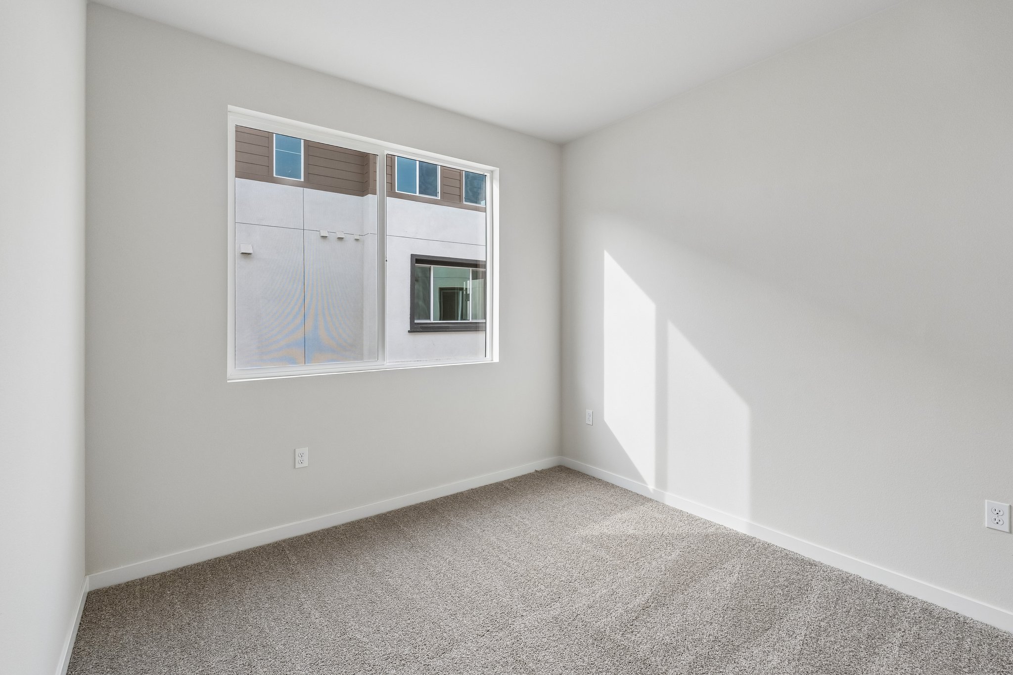 A room with a window and a rug.
