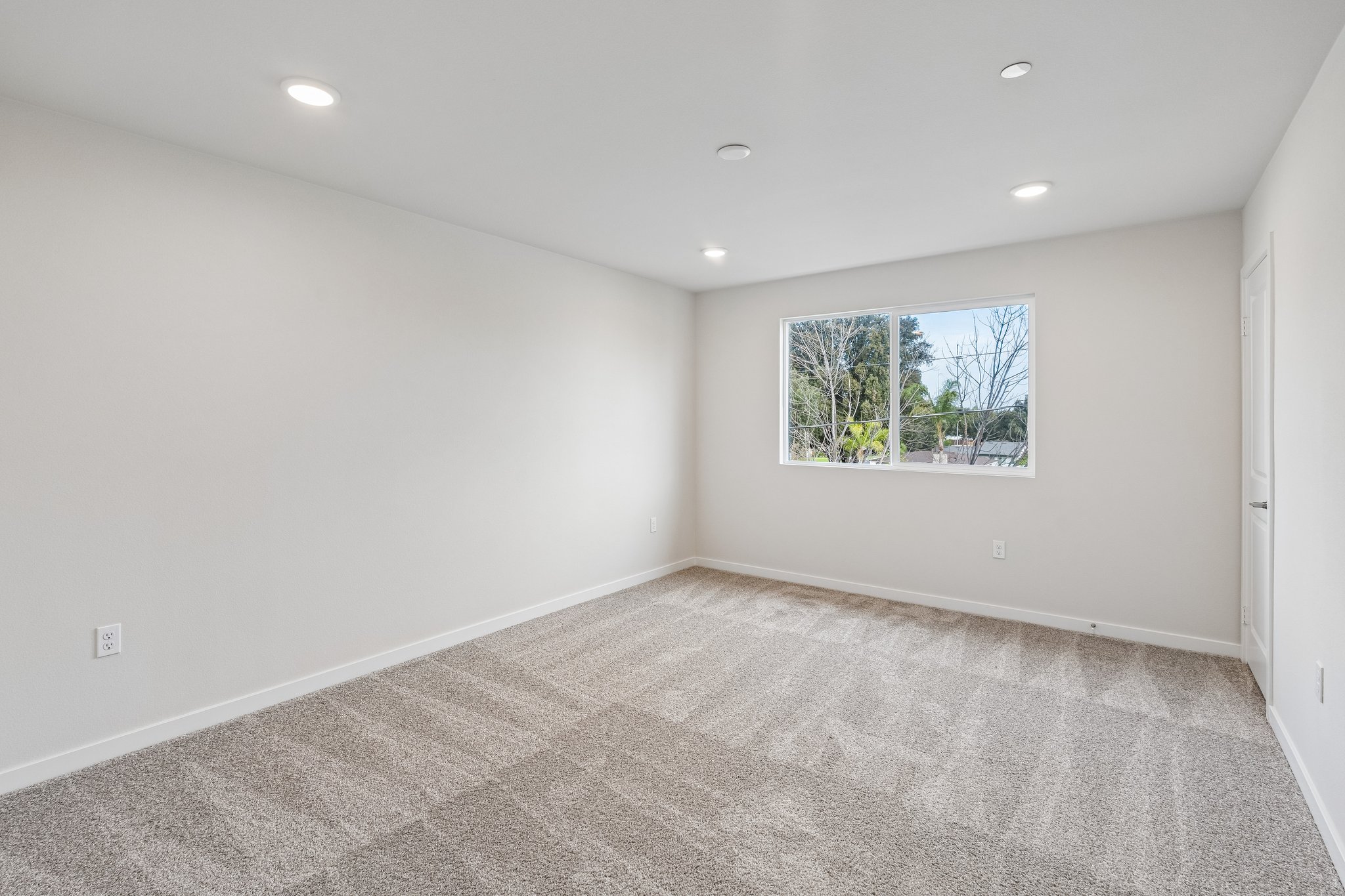 A room with a window and a rug.