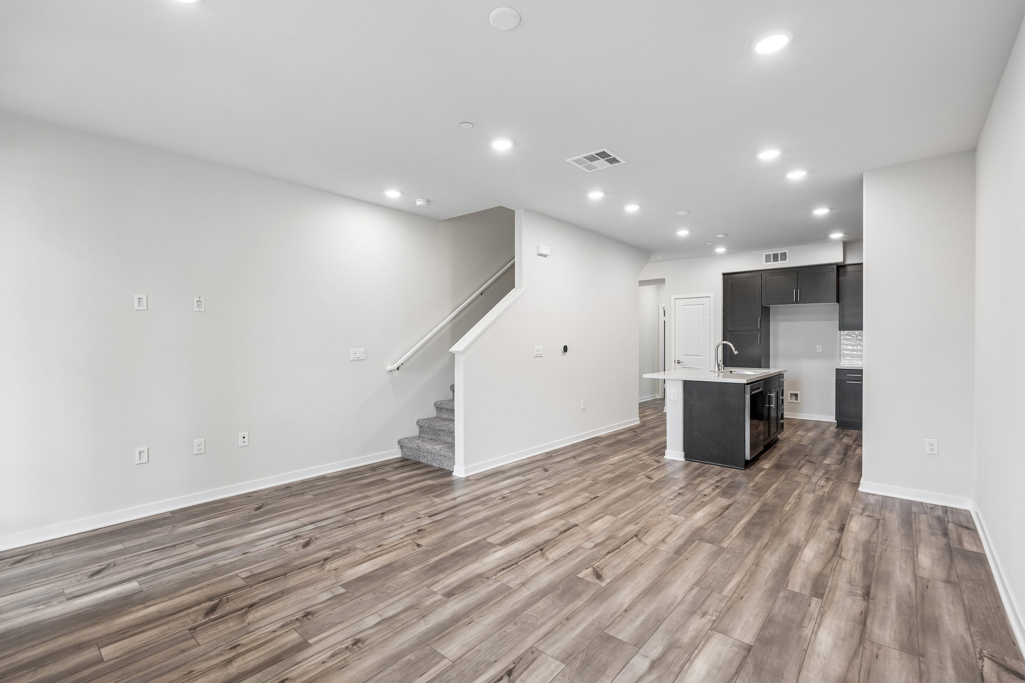A room with white walls and wood floors.