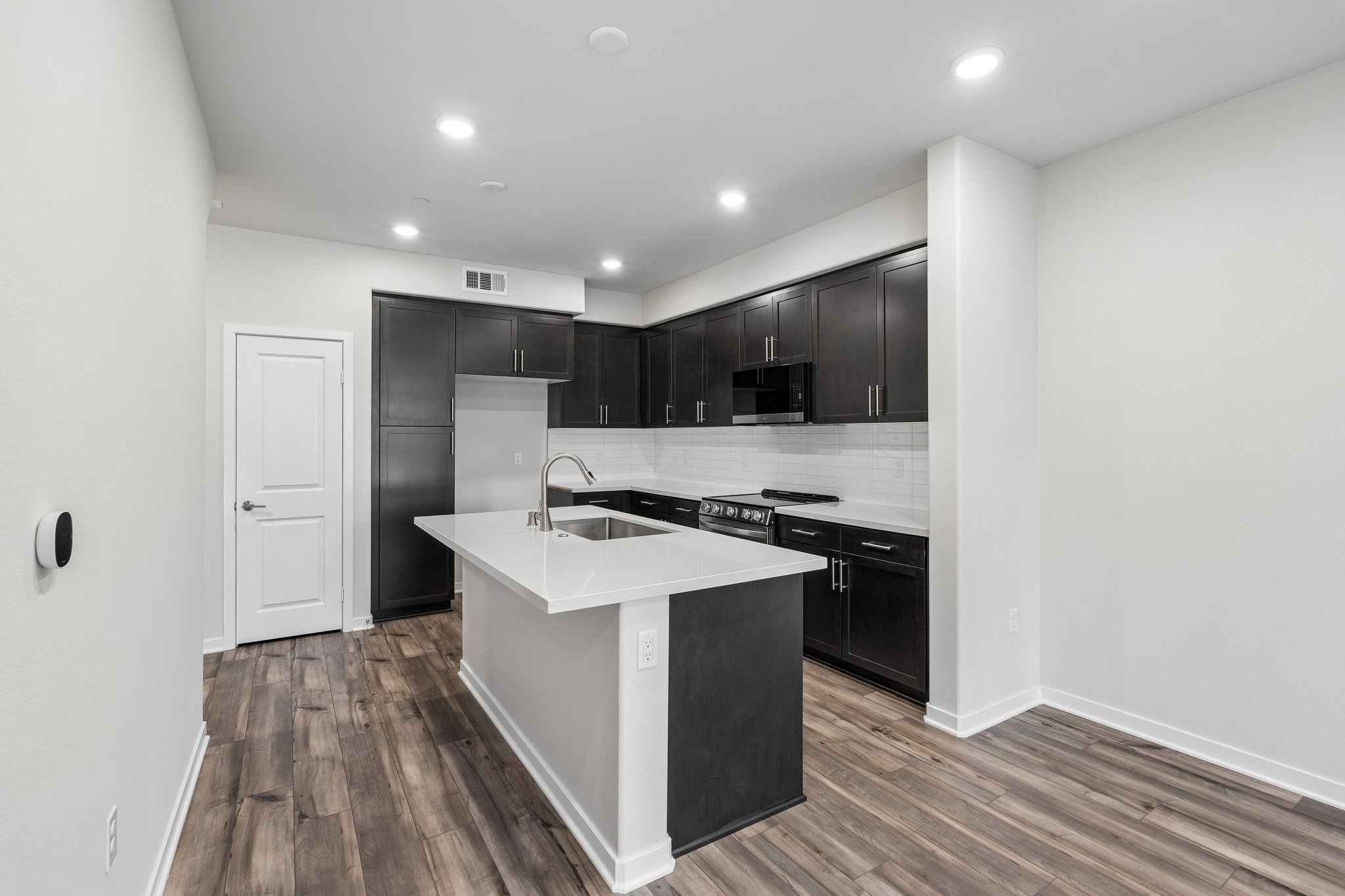 A kitchen with black cabinets.