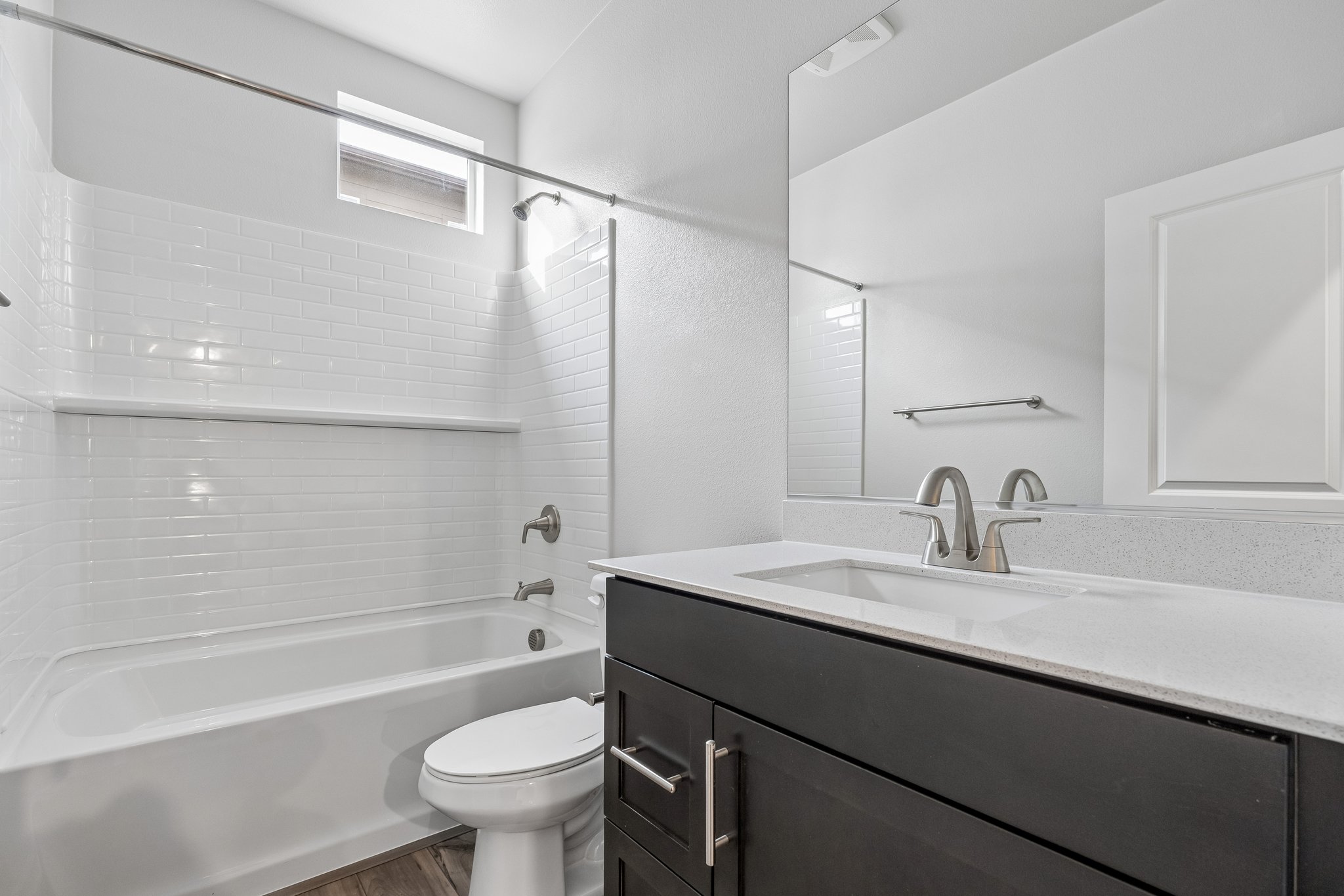 A bathroom with a tub sink and toilet.