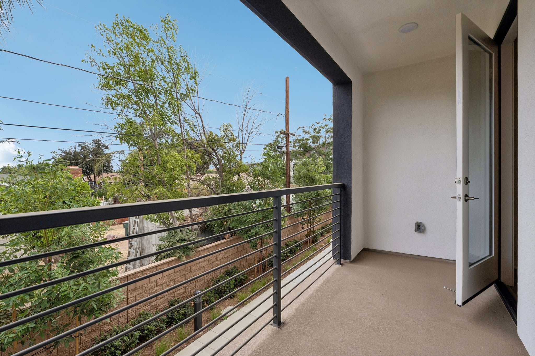 A walkway with a fence and trees.