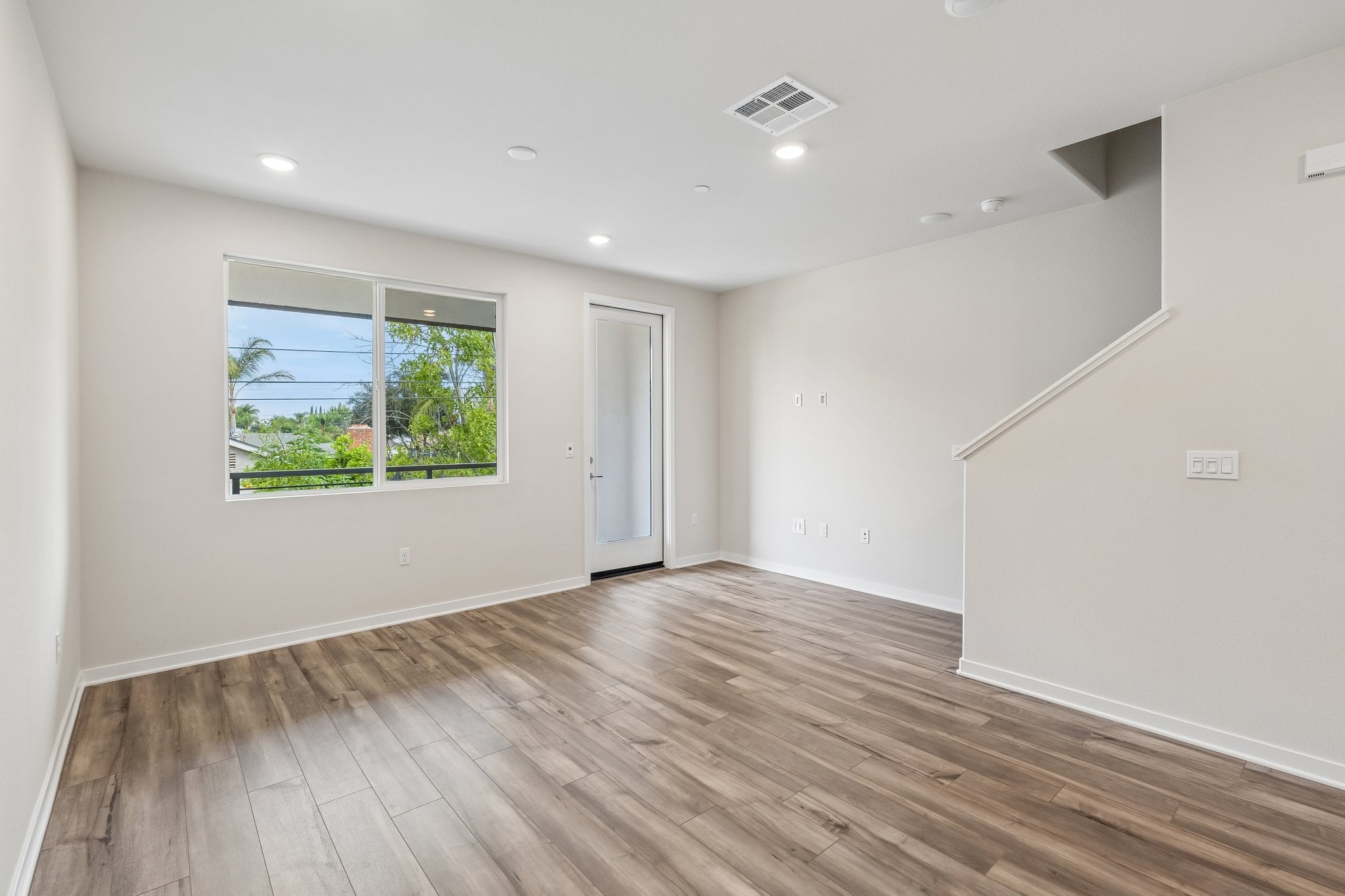 A room with a wood floor and a window.