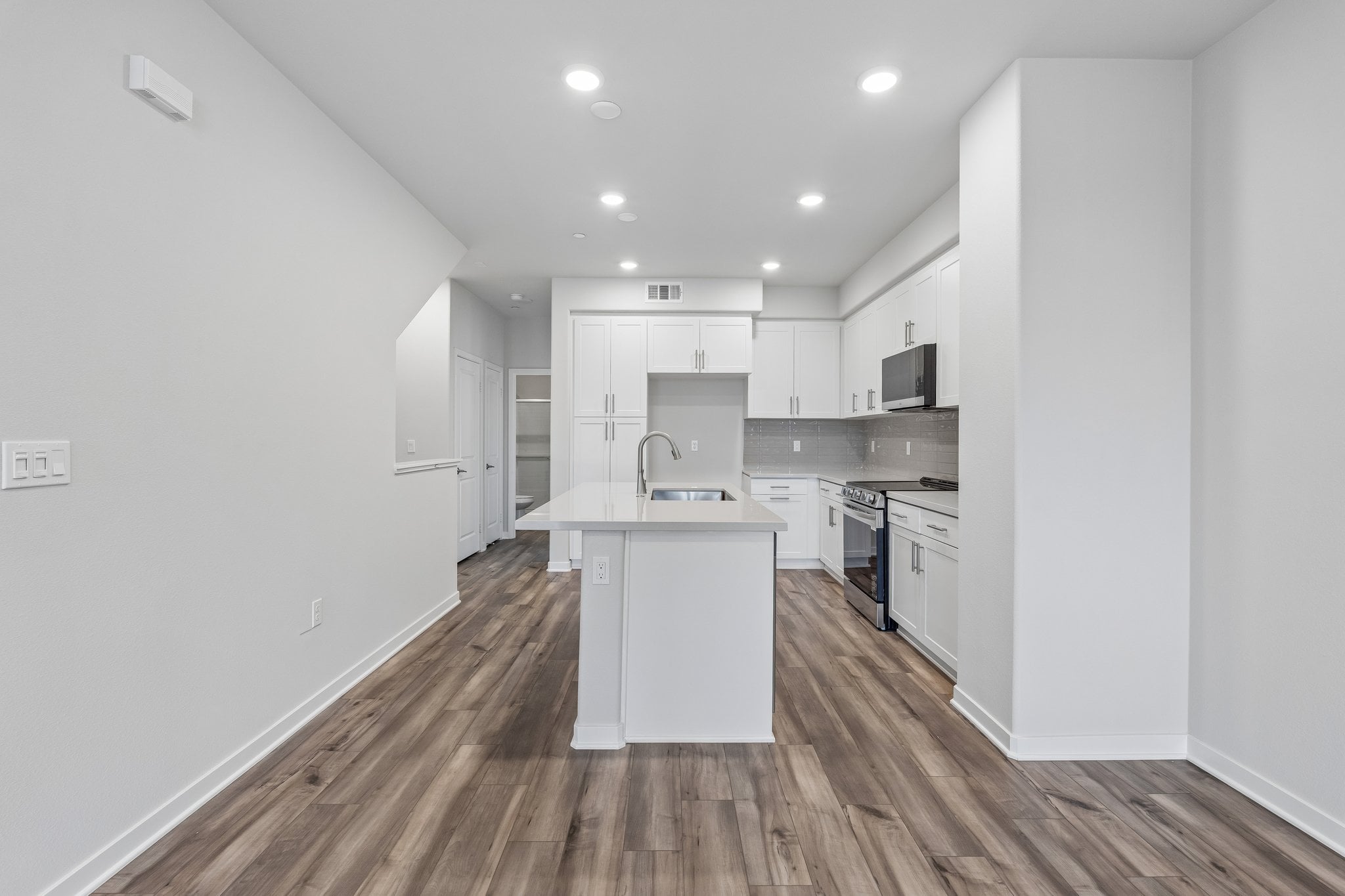 A kitchen with white cabinets.