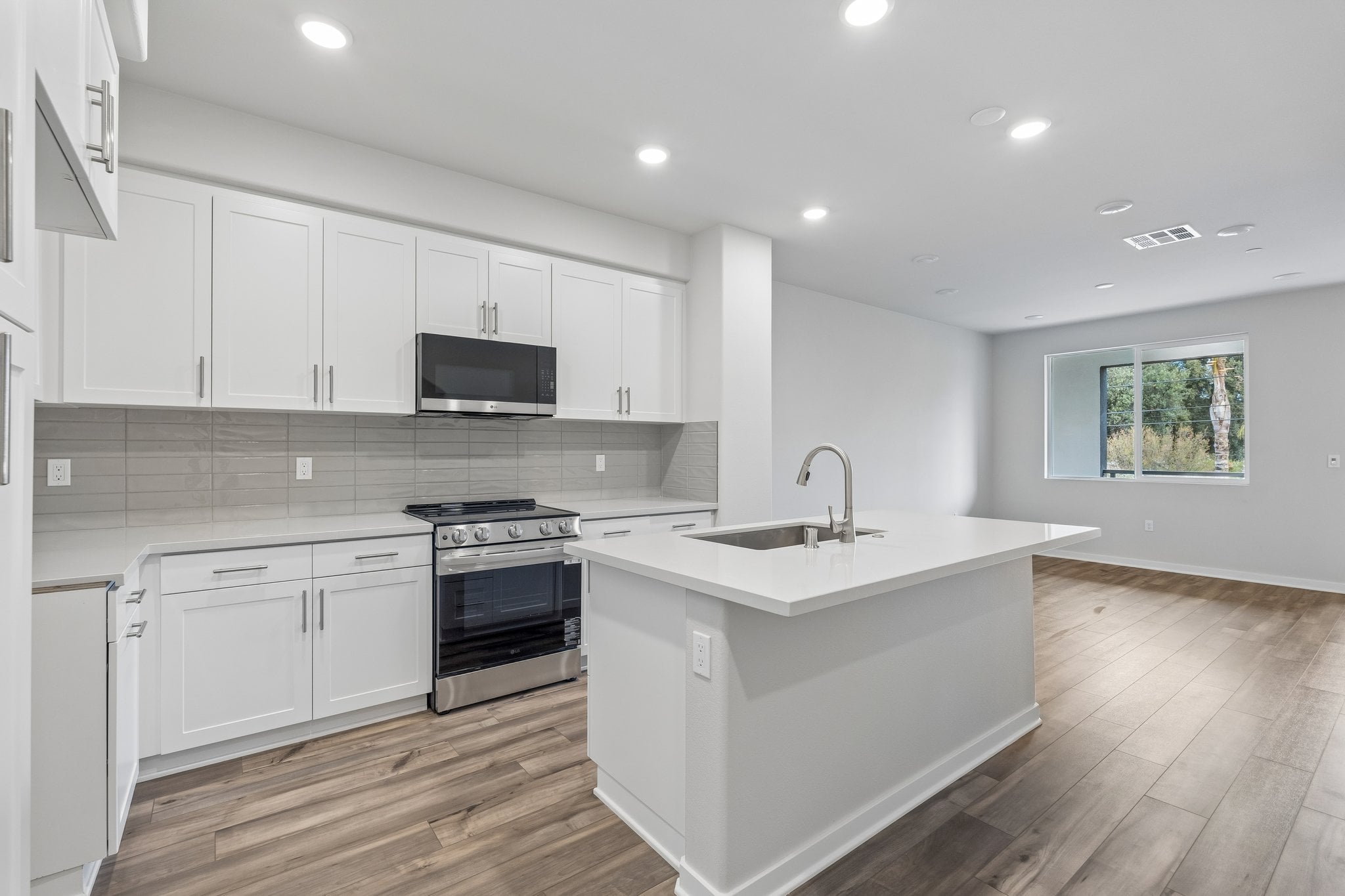 A kitchen with white cabinets.