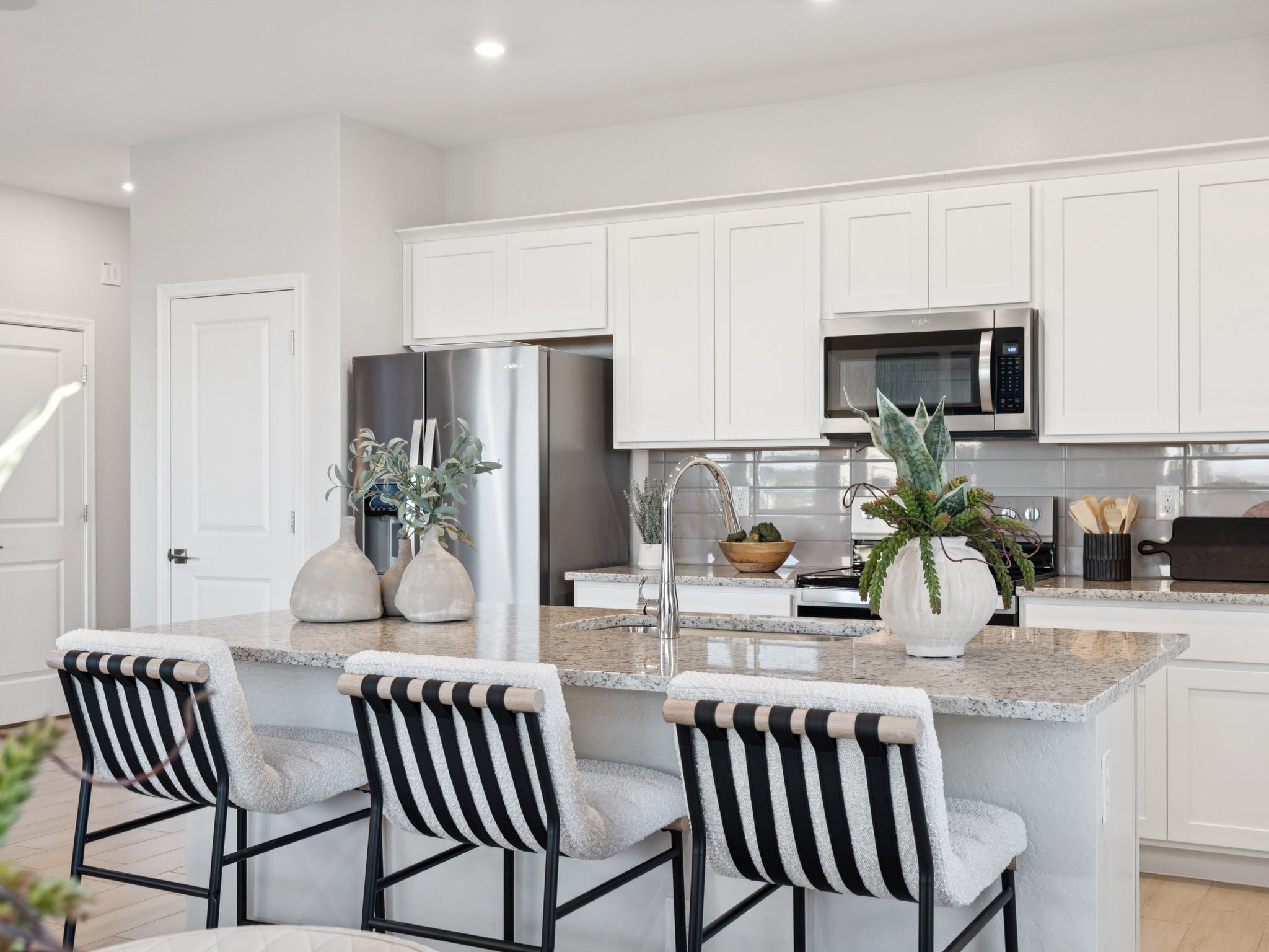A kitchen with white cabinets.