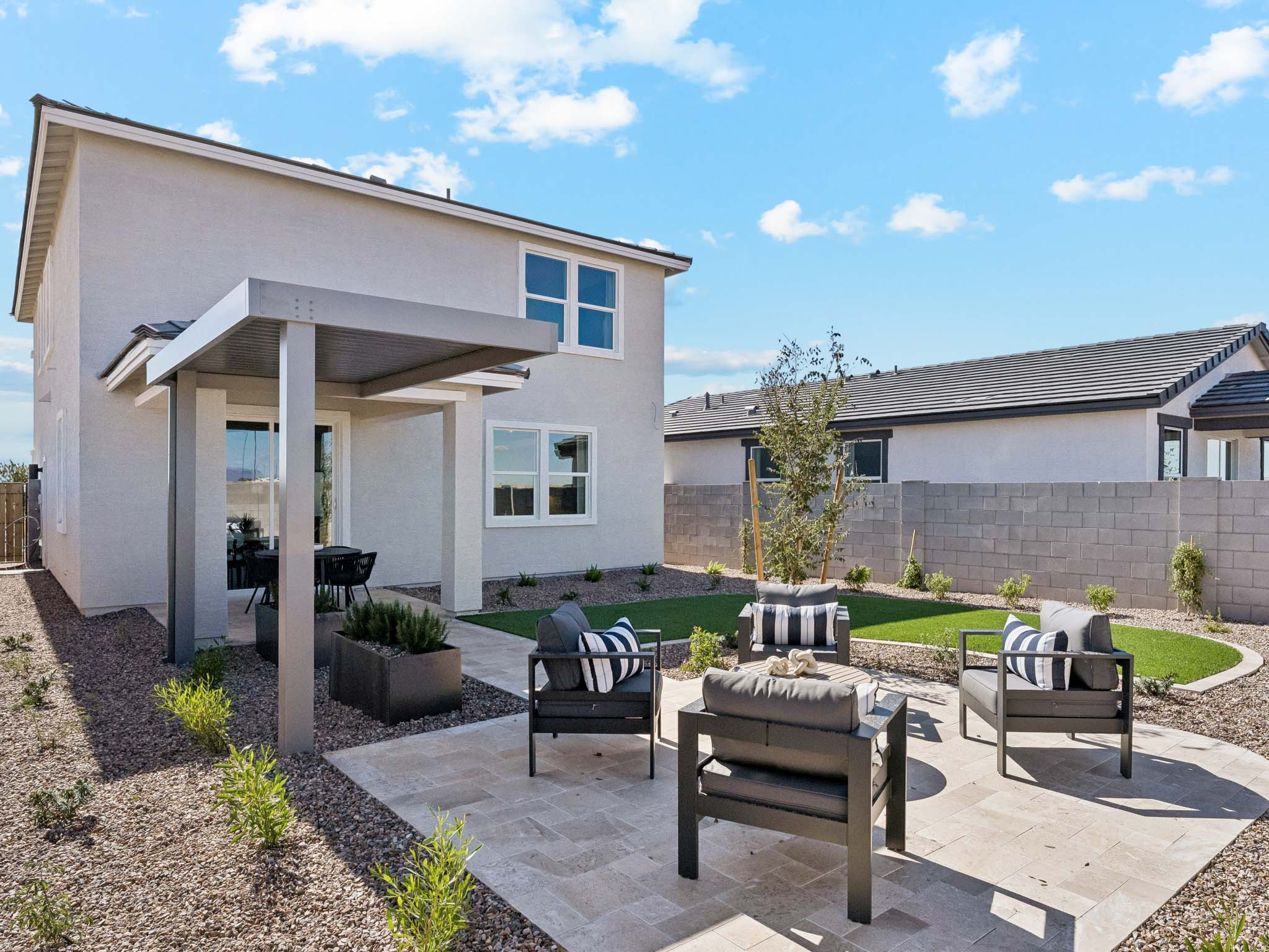 A patio with chairs and tables outside a house.