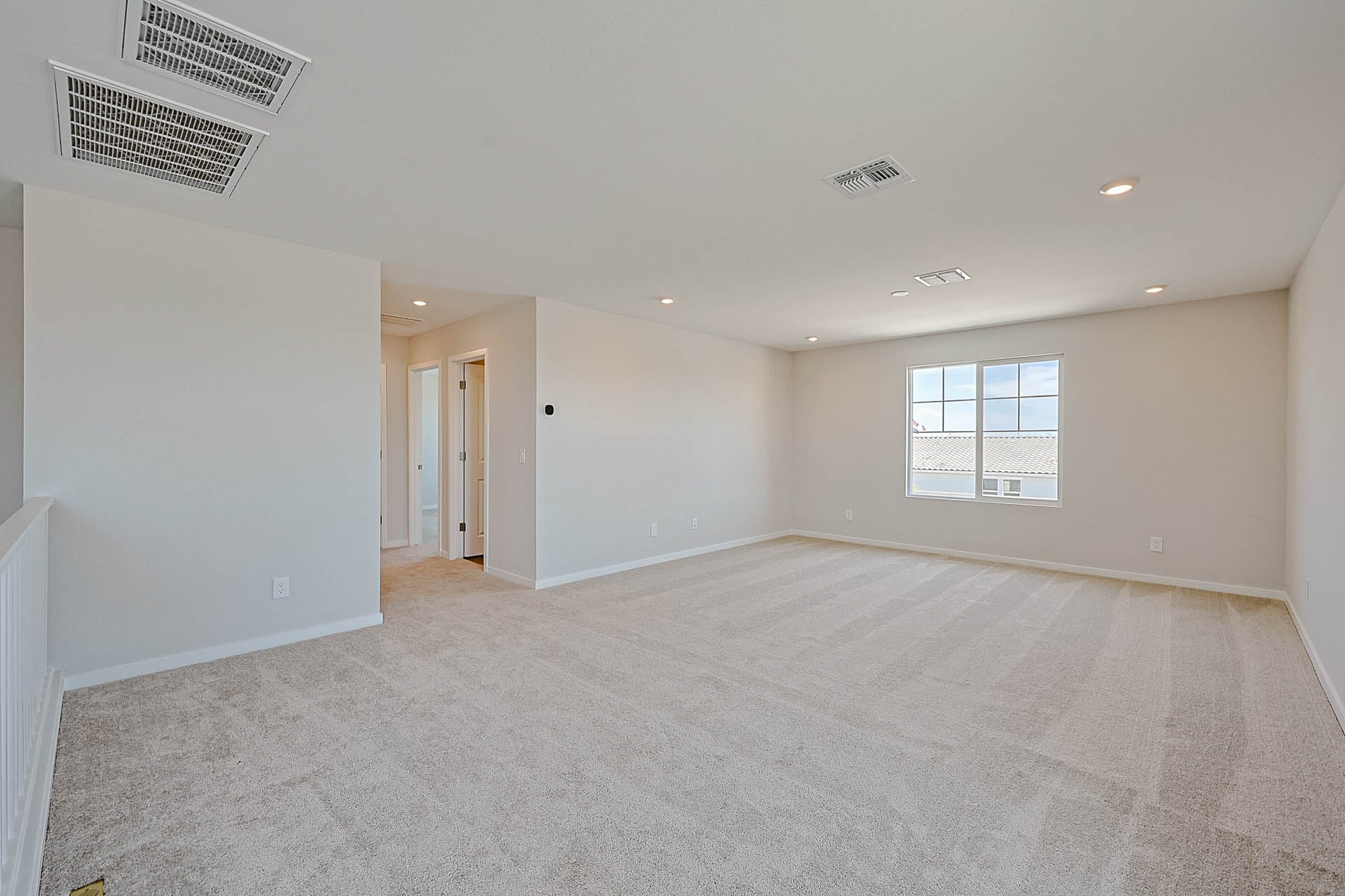 A room with a carpet and a window.