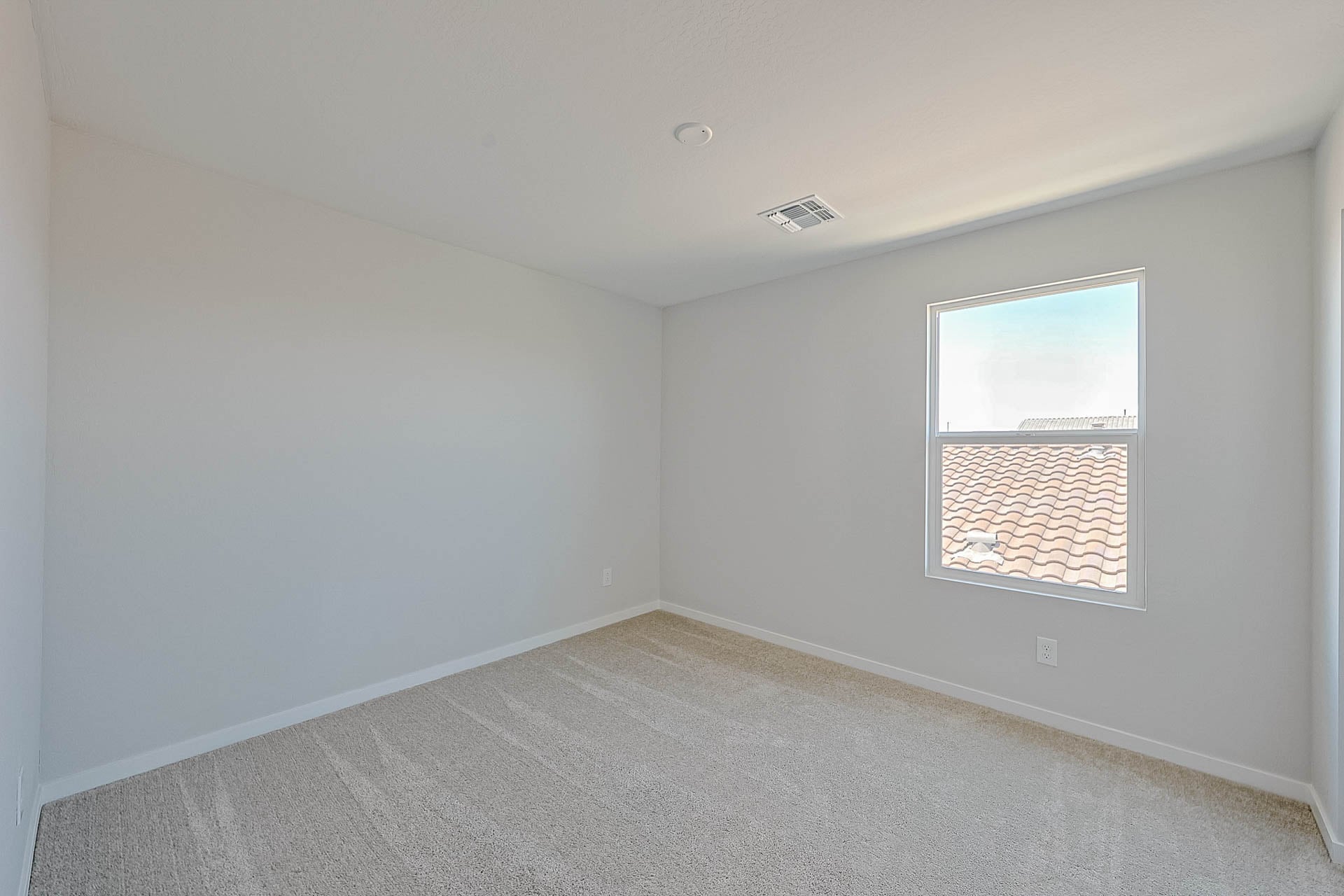 A room with a window and a carpet.