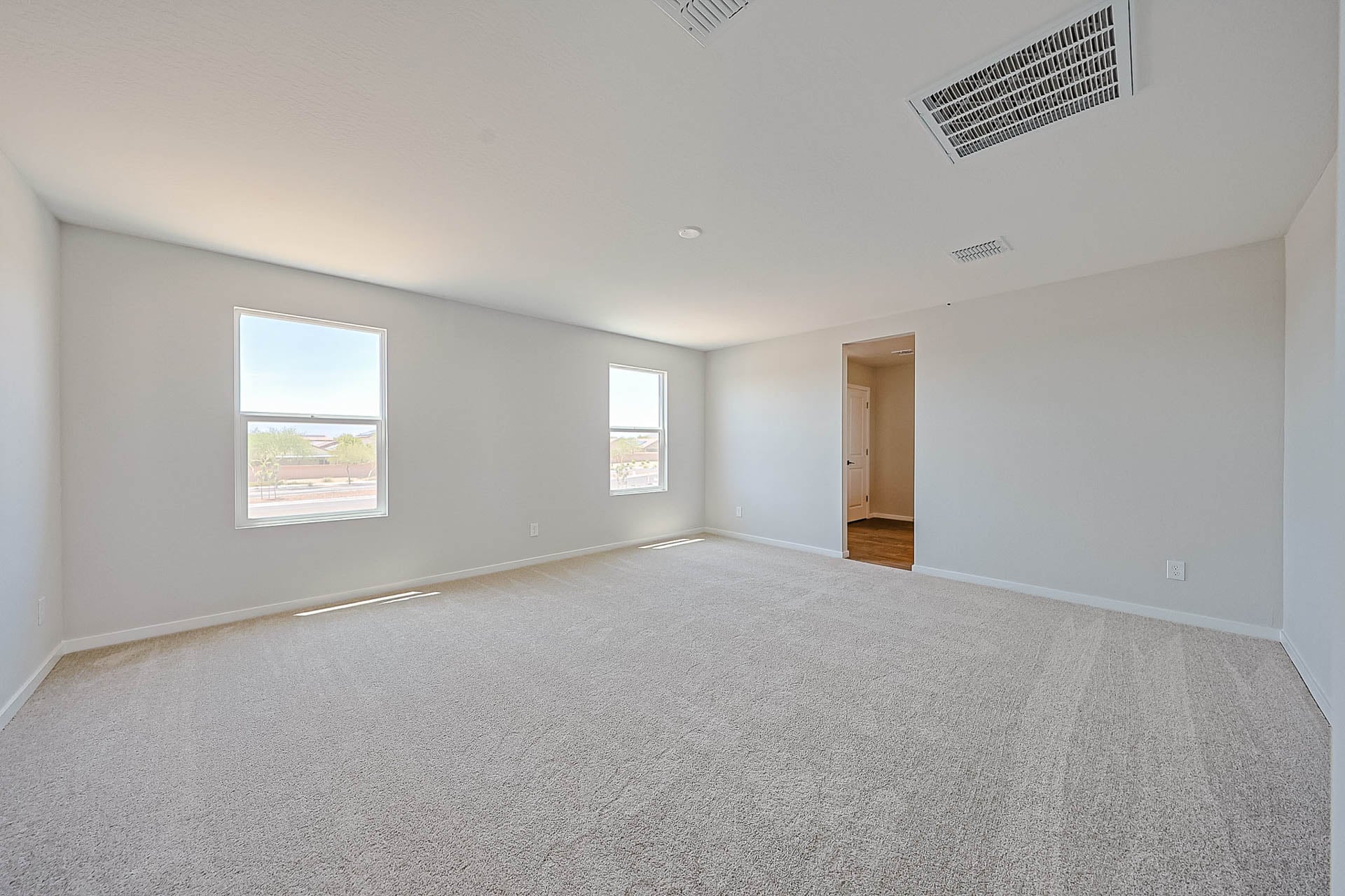 A room with a carpet and windows.
