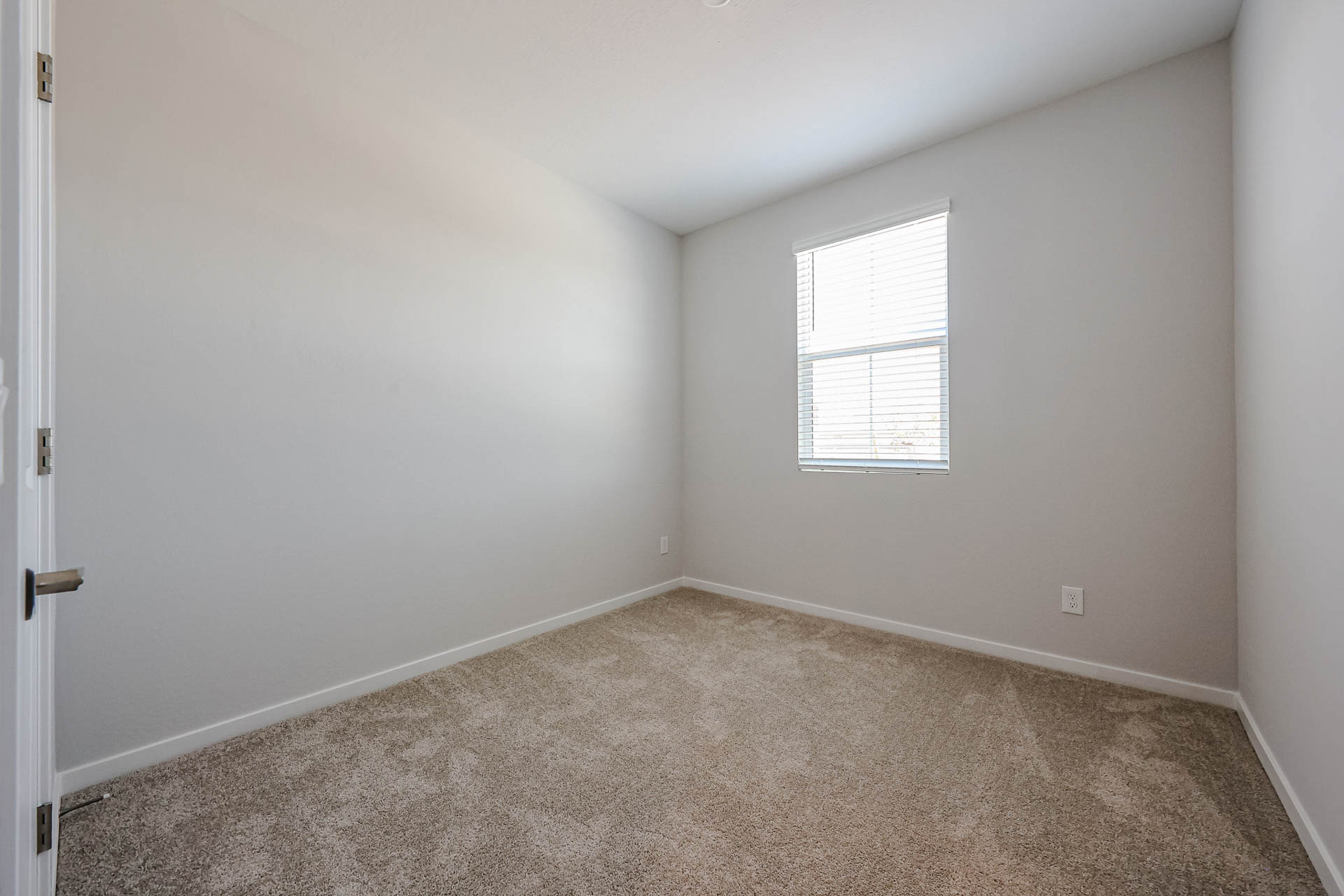 A room with a carpet and a window.